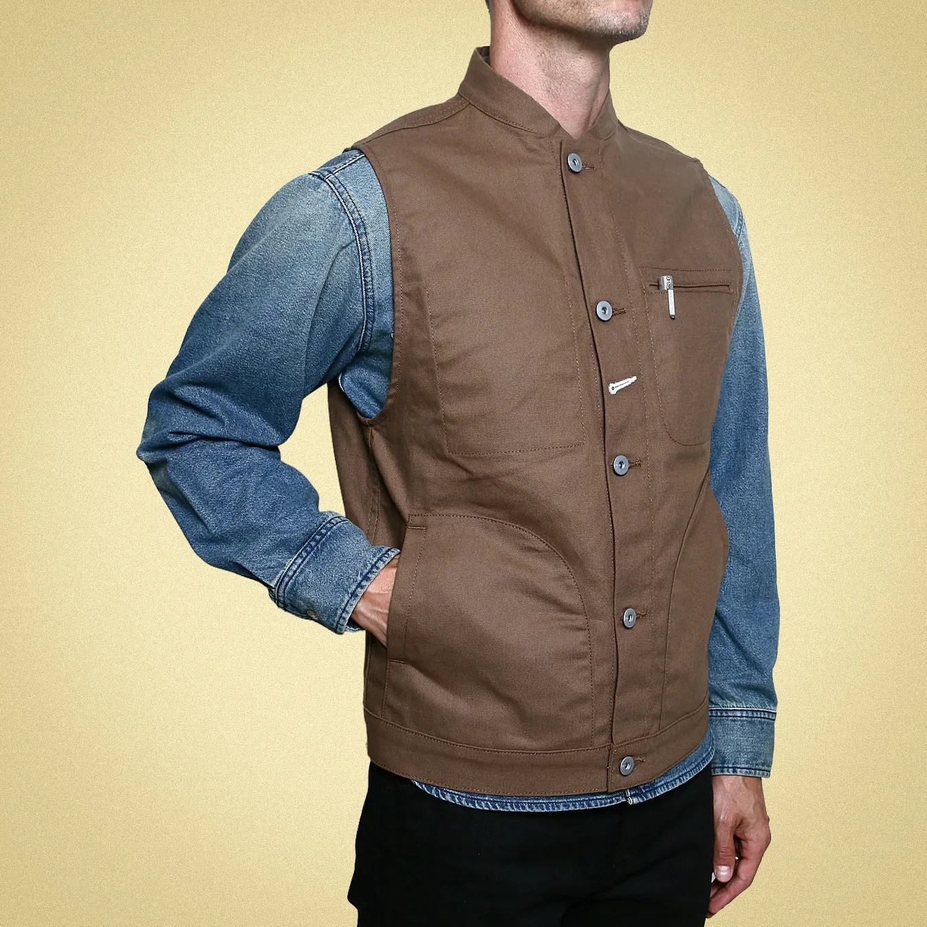 Brown button-up vest with a stand collar worn over a blue denim shirt.