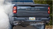 Rear view of a dark gray RAM Bighorn 4x4 pickup truck with Michigan license plate AD 4507, emitting smoke.