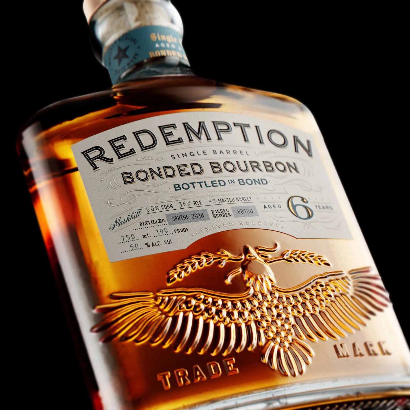 Close-up of a Redemption Bonded Bourbon bottle label showing 6 years aged, 50% alcohol, and an embossed eagle design.
