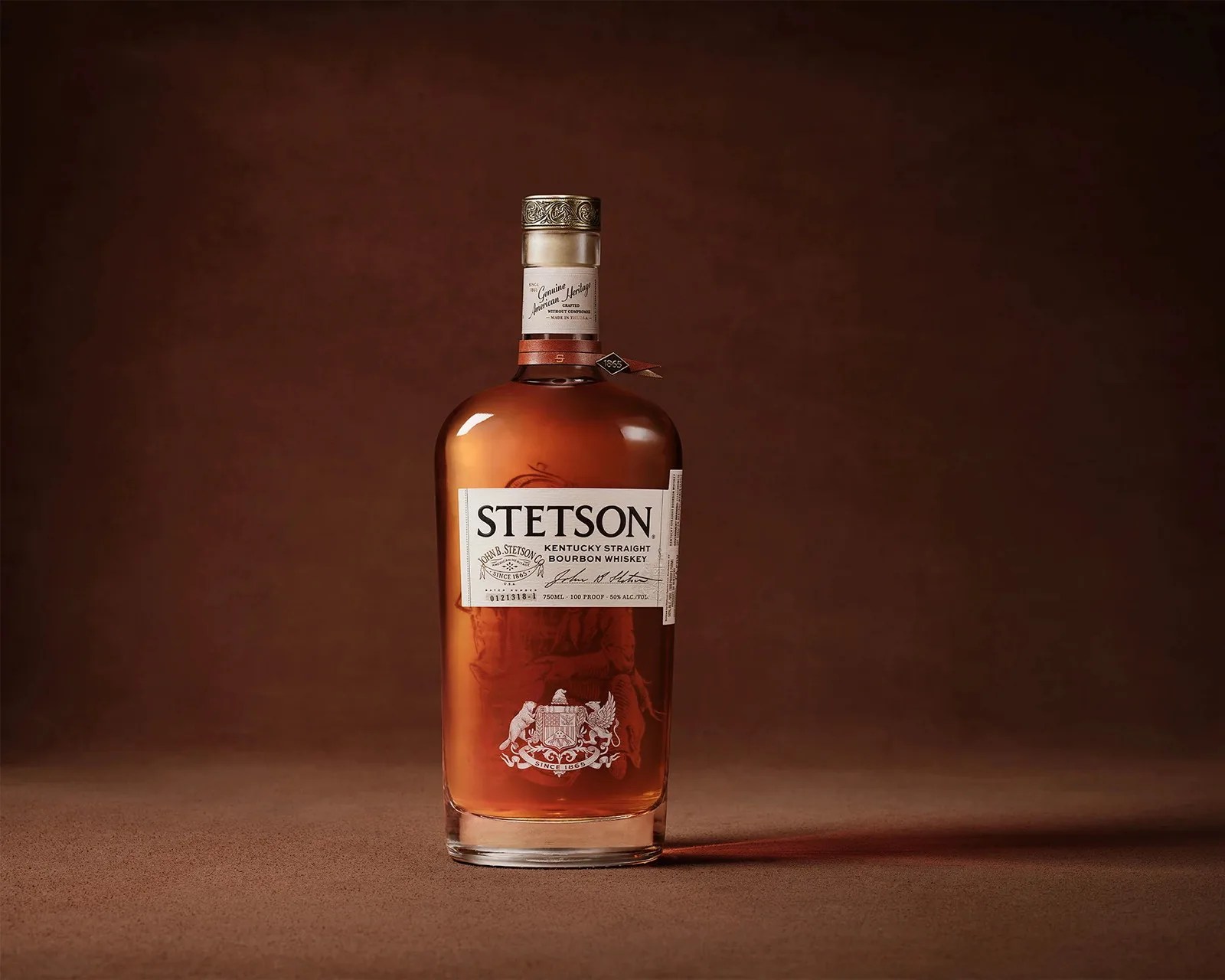 Amber Stetson Kentucky Straight Bourbon Whiskey bottle with white label on brown surface and background.