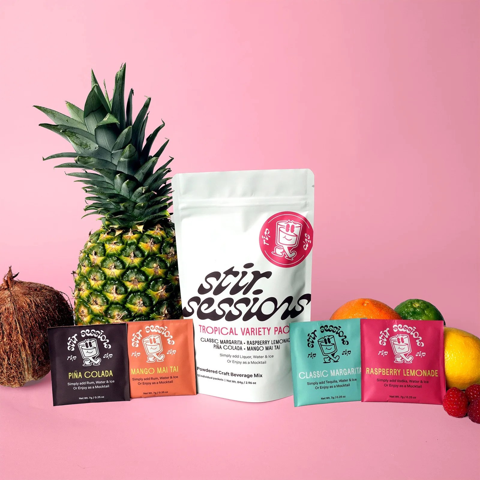 White pouch labeled "stir sessions tropical variety pack" with four colorful drink mix packets and assorted fruits on a pink background.