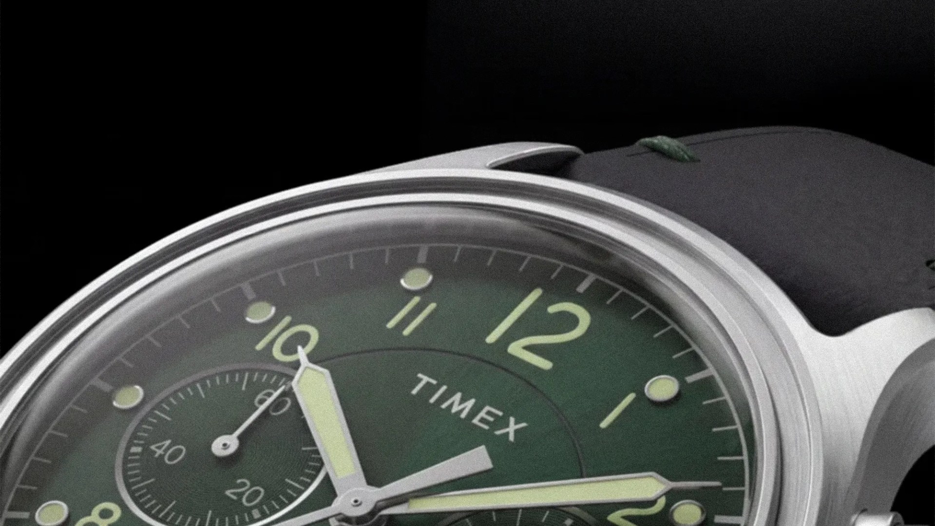 Close-up of a Timex watch with a green dial, luminous hands, and a black leather strap.