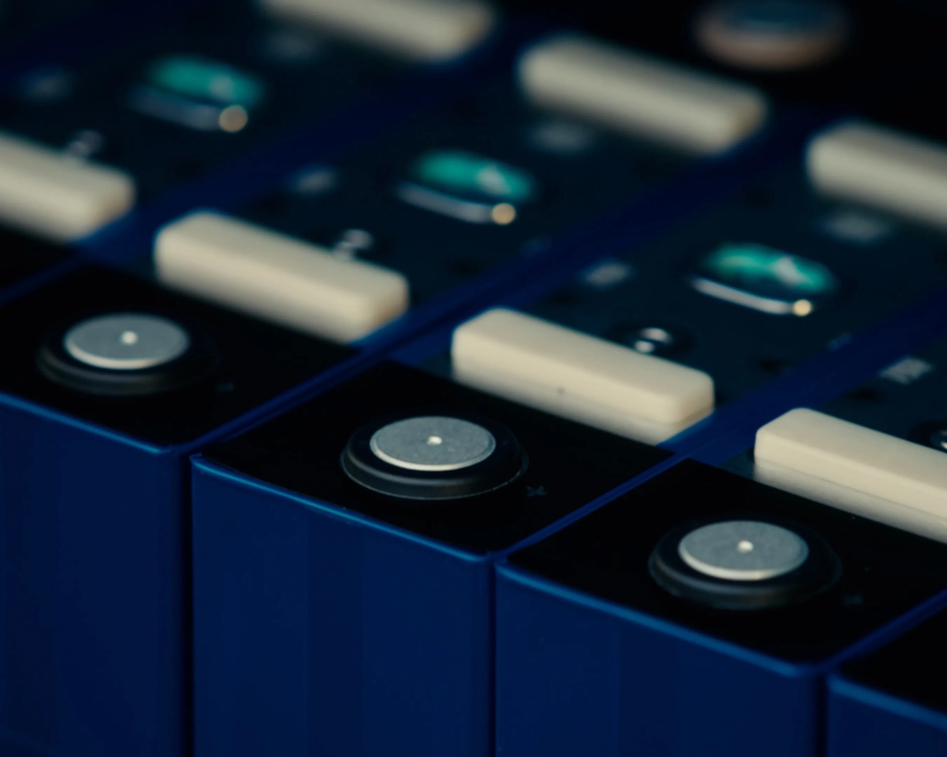 Close-up of blue electronic devices with white rectangular buttons and circular silver dials.