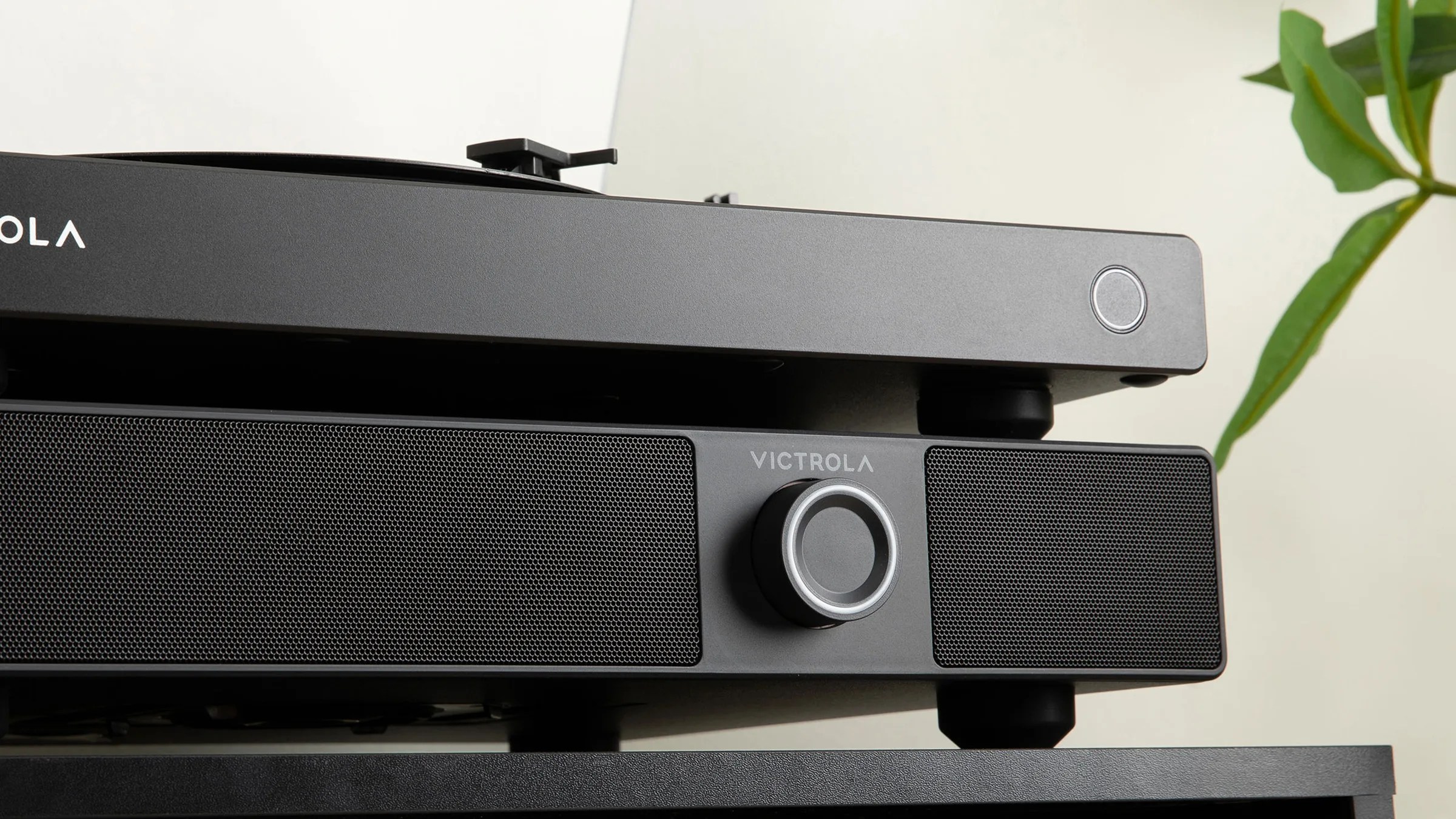 Black Victrola speaker with central volume knob below a black turntable with a power button on the right side.