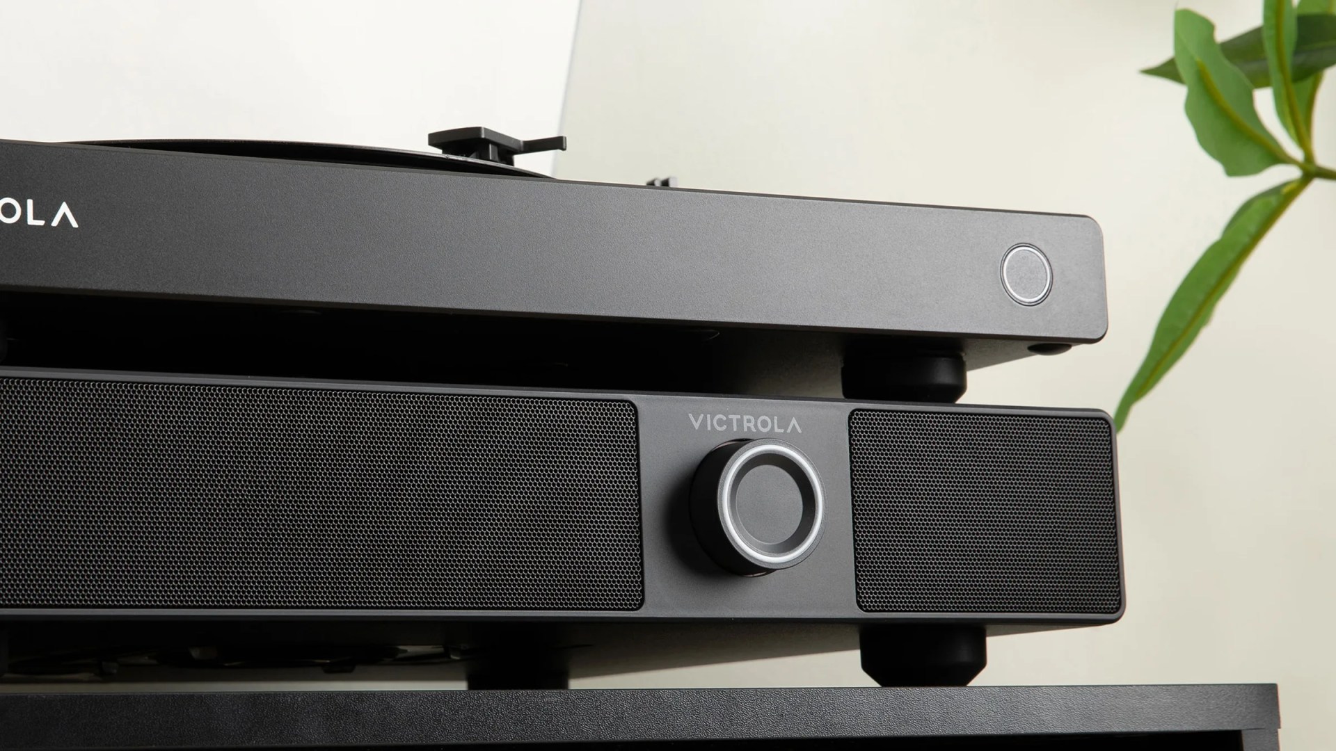 Black Victrola speaker with central volume knob below a black turntable with a power button on the right side.