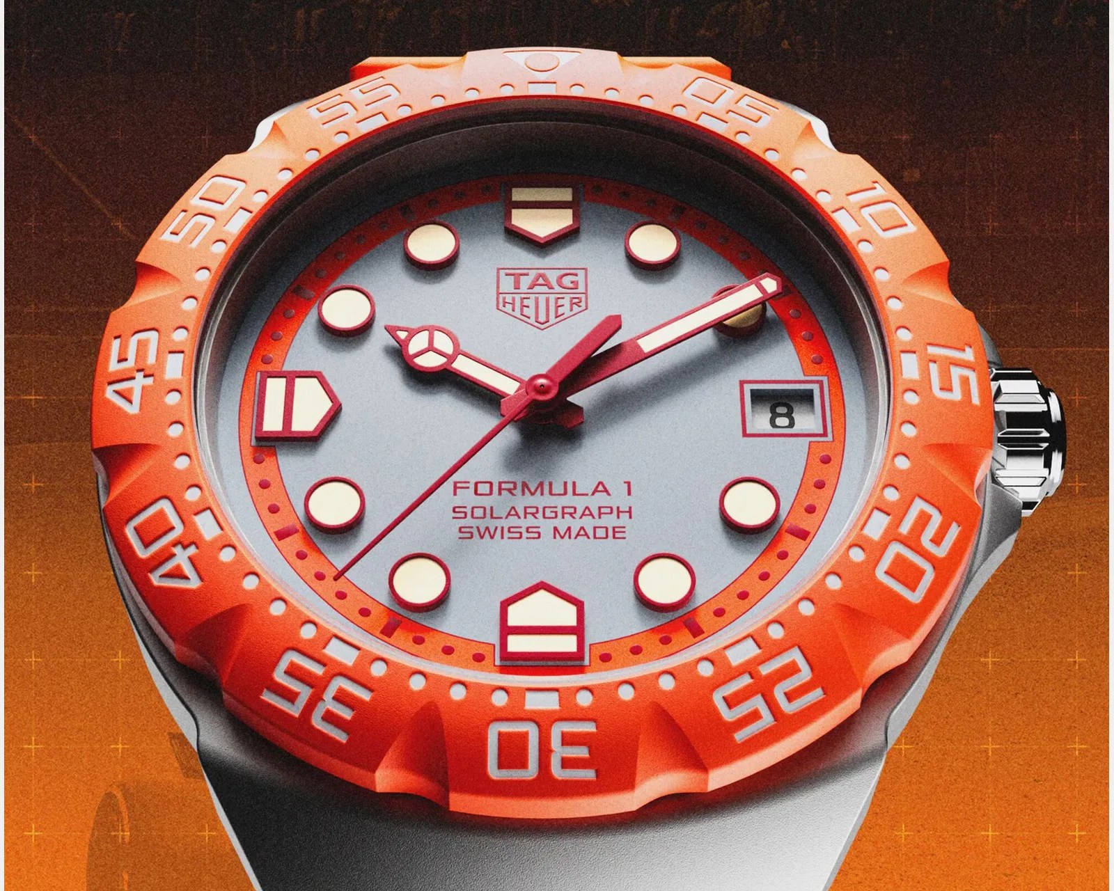 TAG Heuer Formula 1 Solagraph watch with orange bezel, silver dial, red markers, and date window at 3 o'clock.