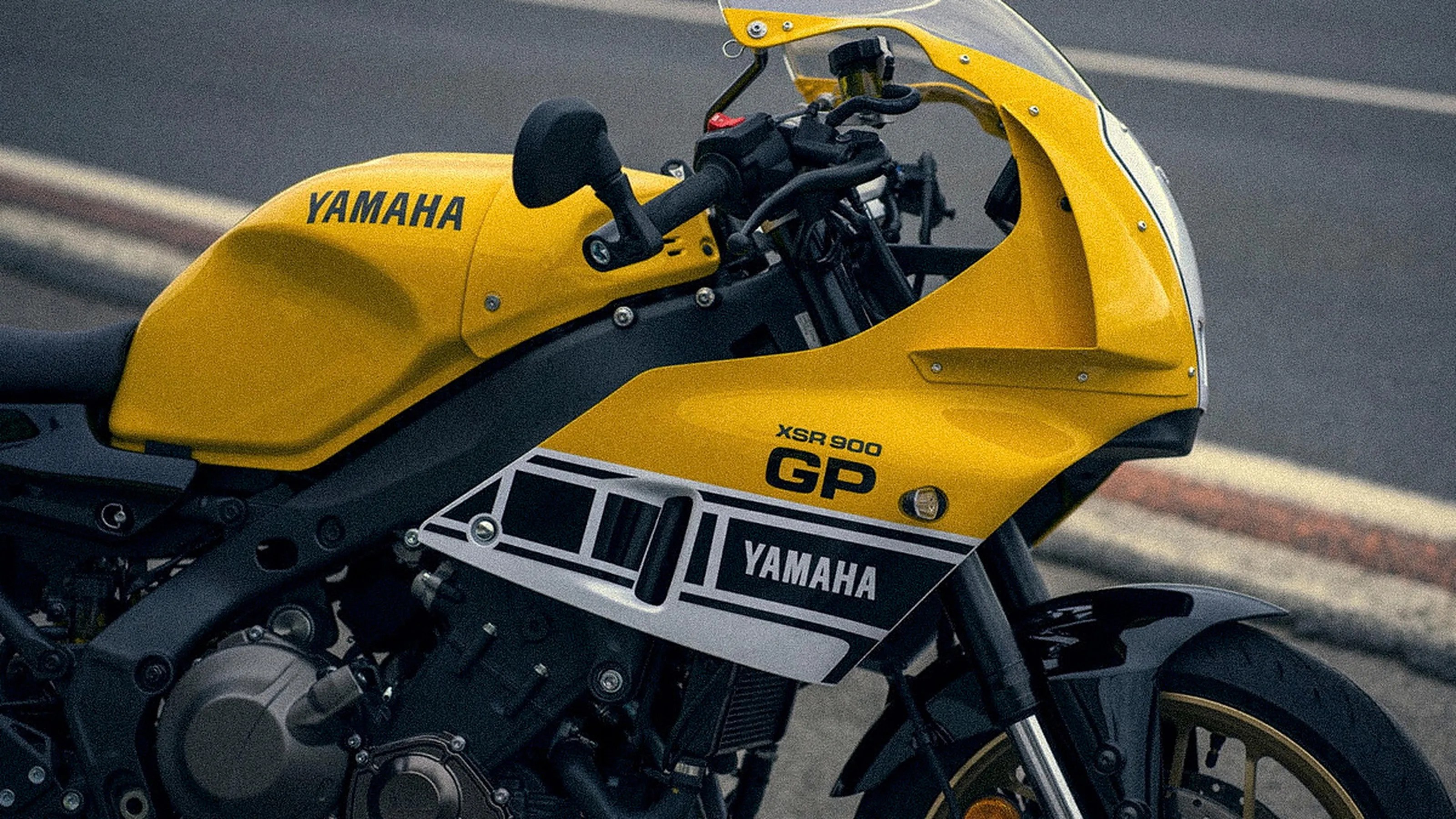 Yellow Yamaha XSR 900 GP motorcycle with black and white detailing on a road.