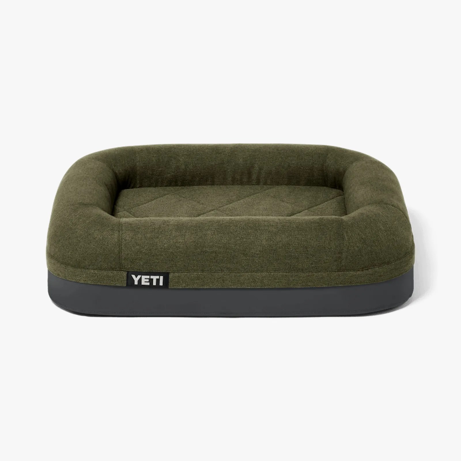 Olive green and dark gray rectangular dog bed with raised cushioned sides and YETI logo tag.