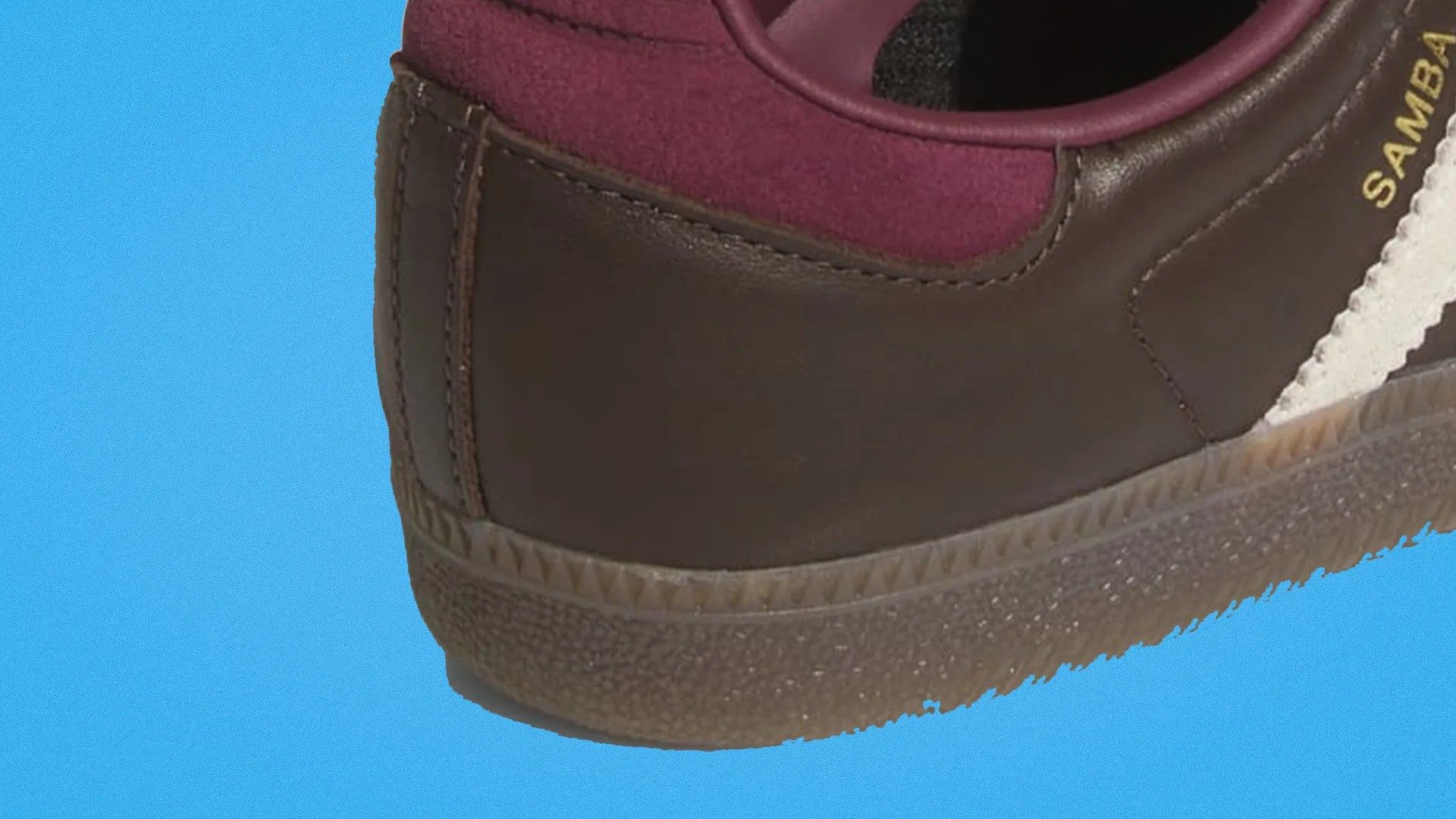 Close-up of a brown leather sneaker heel with burgundy suede collar and gum sole on a blue background.