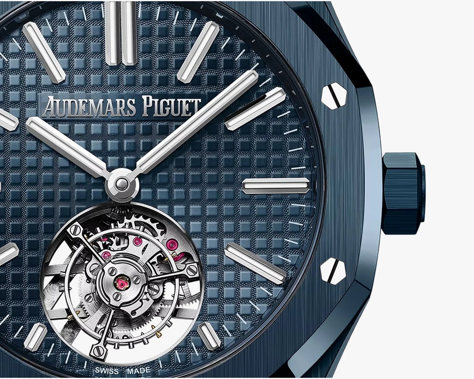 Close-up of a blue Audemars Piguet watch face with silver hour markers and visible tourbillon mechanism.