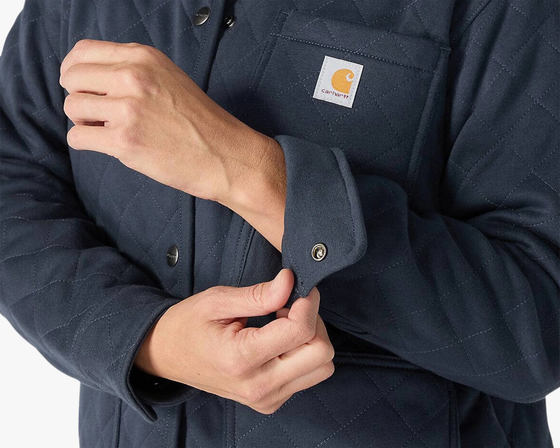 Navy quilted Carhartt jacket with snap button cuffs and chest pocket worn by a person.