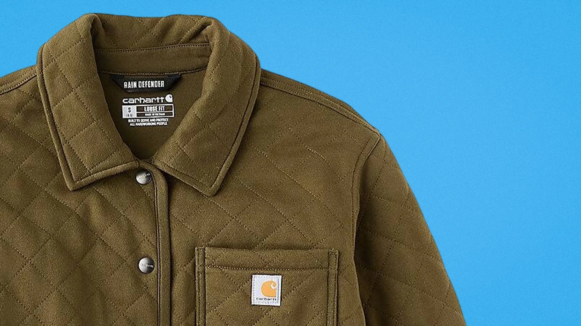 Olive-green quilted Carhartt jacket with snap buttons and chest pocket on blue background.