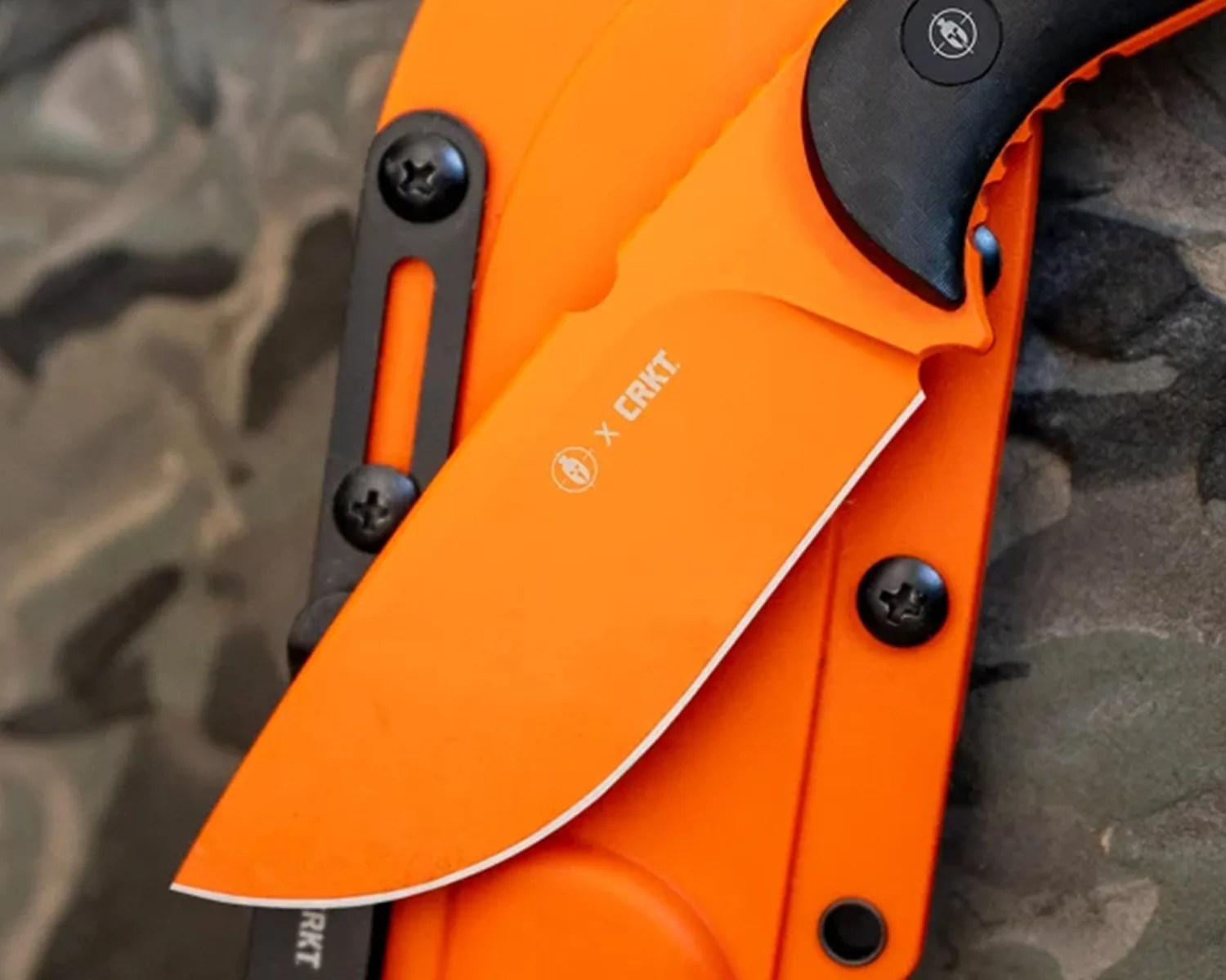 Orange fixed-blade knife with black handle and sheath, blade marked with "X CRKT" logo.