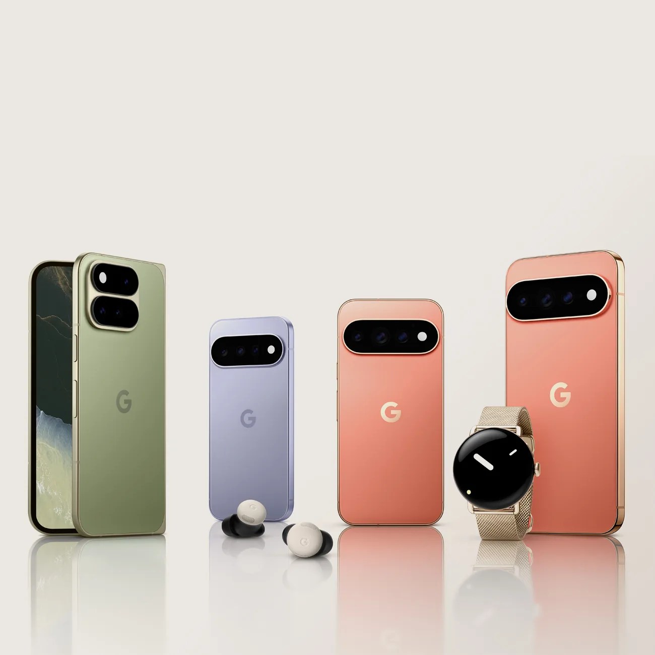 Four Google Pixel smartphones in green, purple, and coral colors with Pixel Buds and a Pixel Watch with a gold mesh band on a reflective surface.