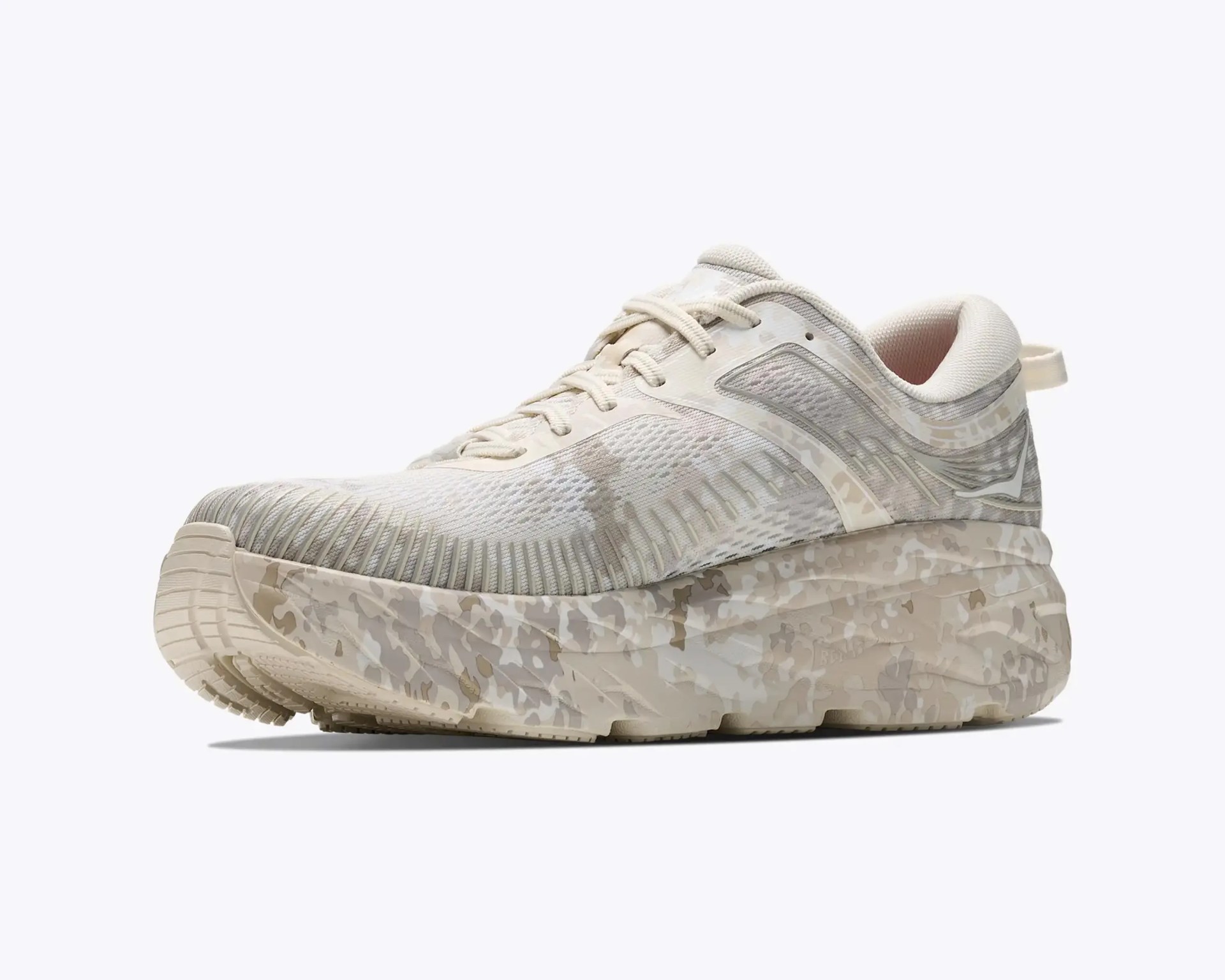 Beige and white camo-patterned athletic shoe with thick sole and mesh upper.