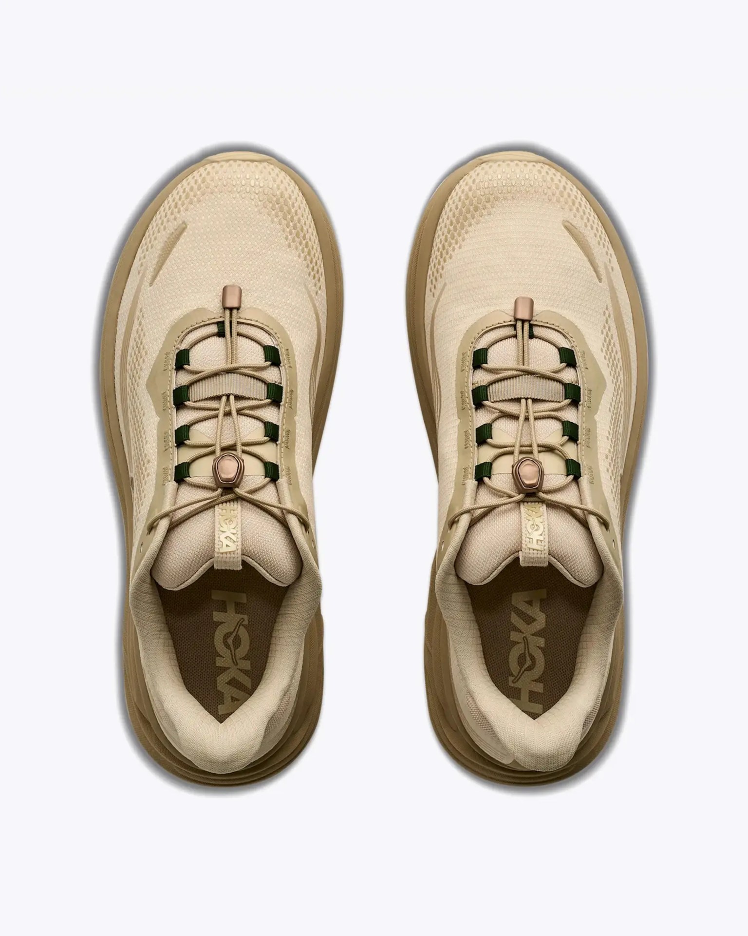 Pair of beige Hoka sneakers with mesh uppers and toggle lace closures viewed from above.