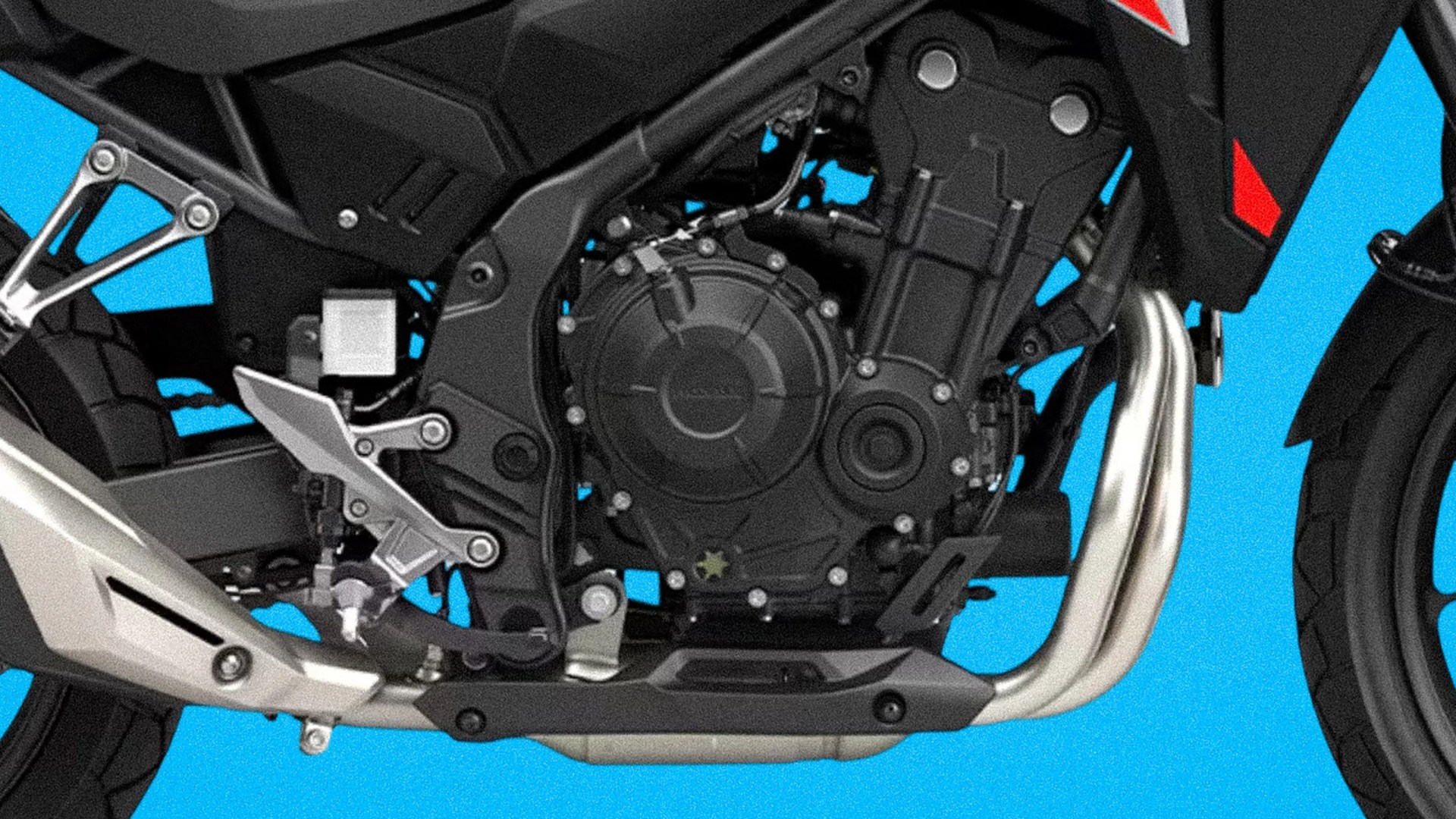Close-up of a black motorcycle engine with silver exhaust pipes and footrest against a blue background.