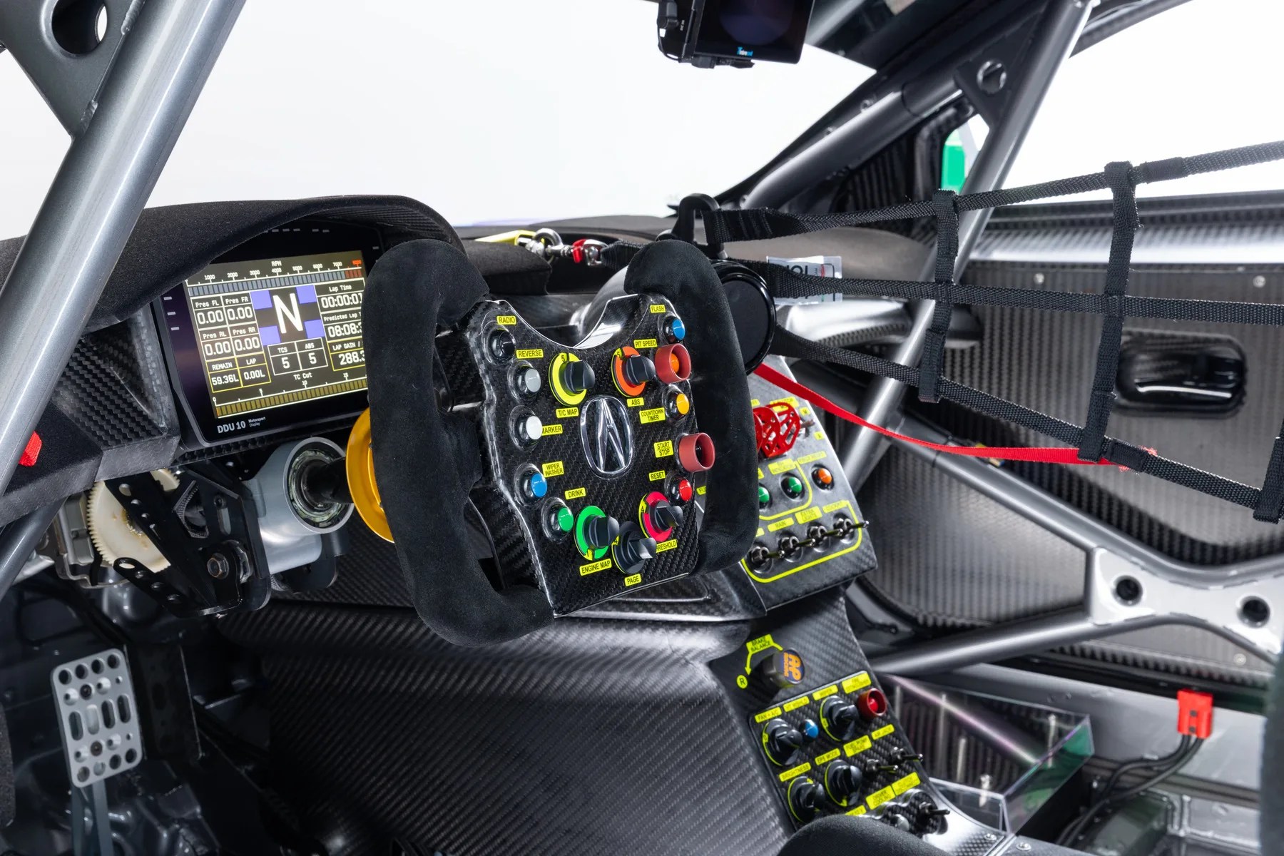 Carbon fiber racing car cockpit with a digital dashboard, multifunction steering wheel, and safety net on the window.