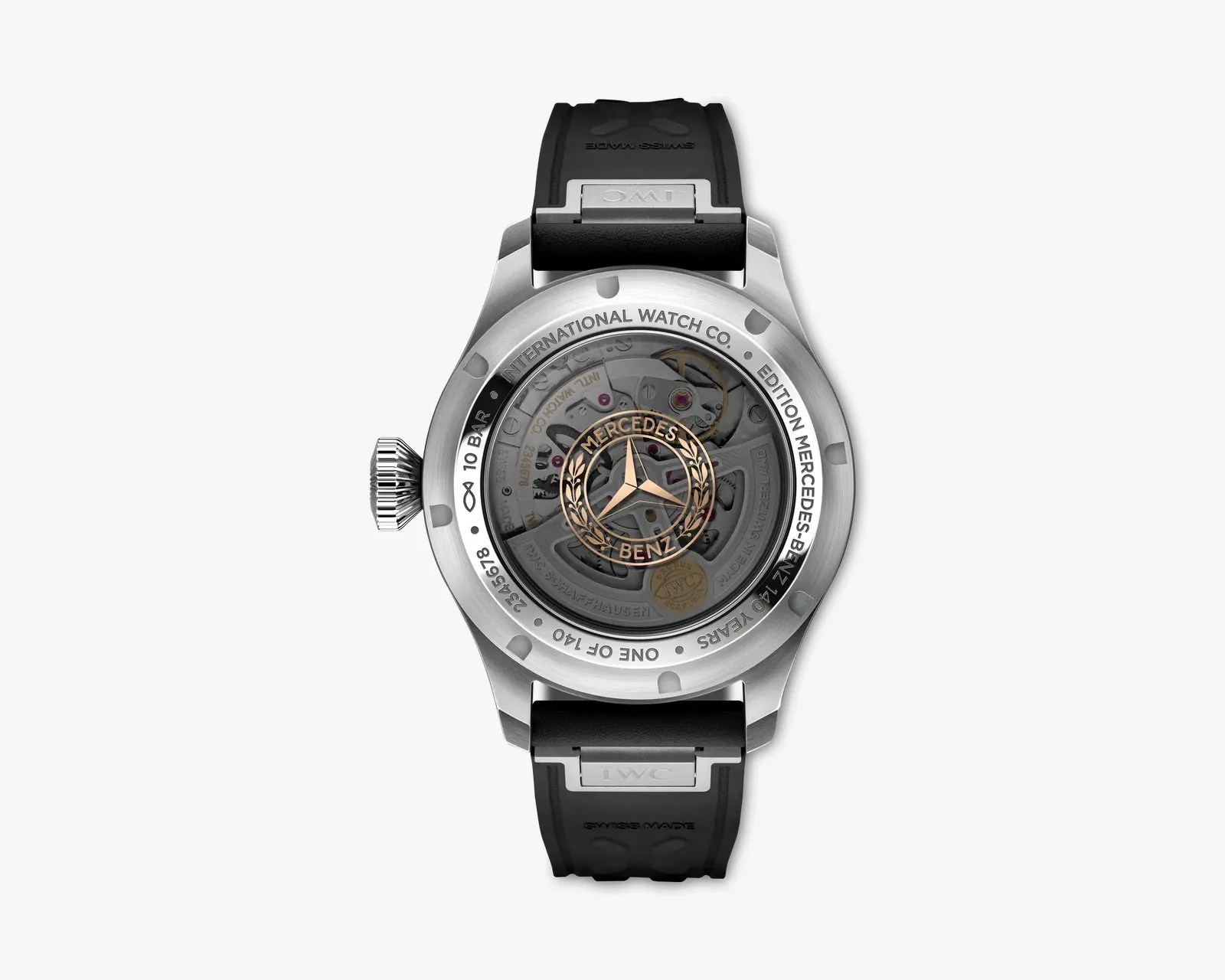 Back view of a silver IWC watch with a black rubber strap and visible mechanical movement featuring a gold Mercedes-Benz logo.
