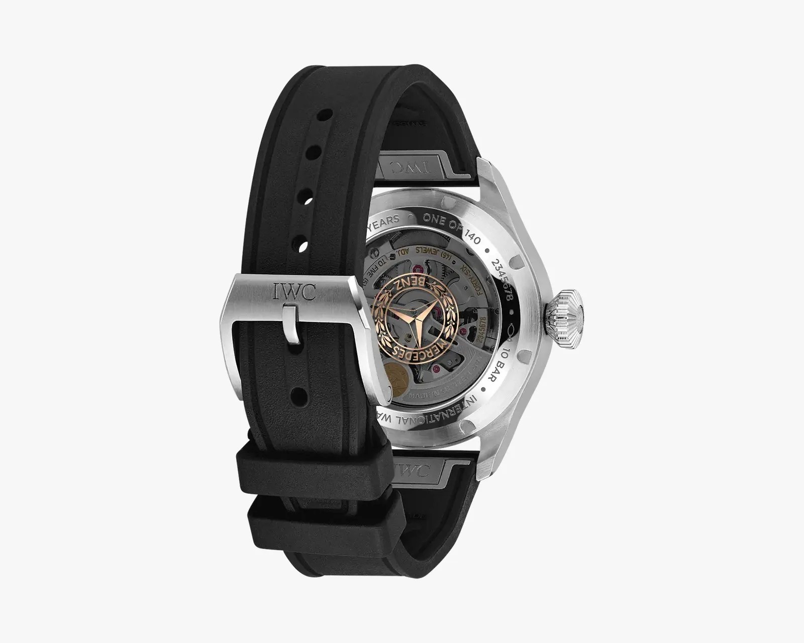 Back view of a silver IWC watch with a black rubber strap and visible mechanical movement inside the case.