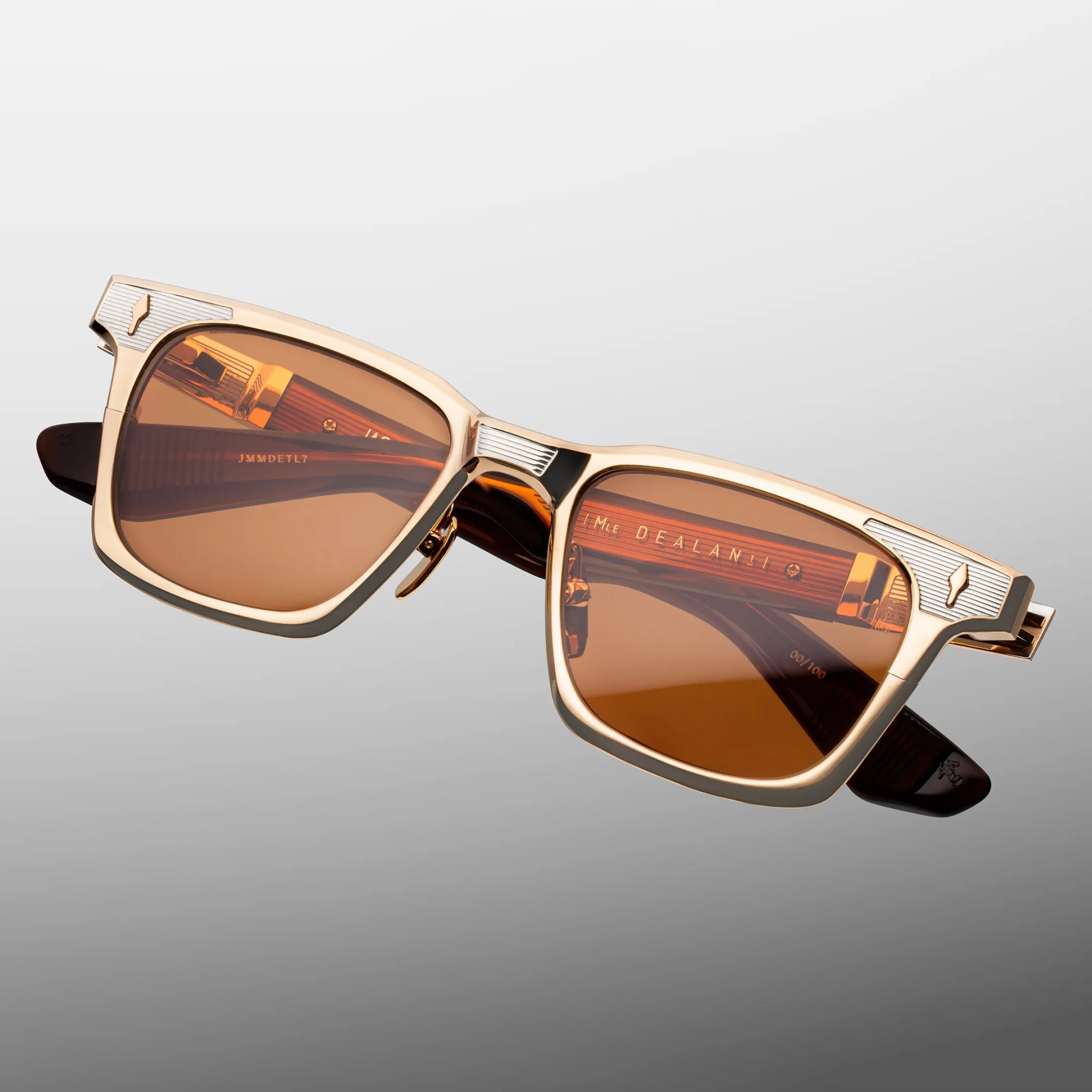 Gold metal-framed sunglasses with amber lenses and ribbed silver accents on the corners.