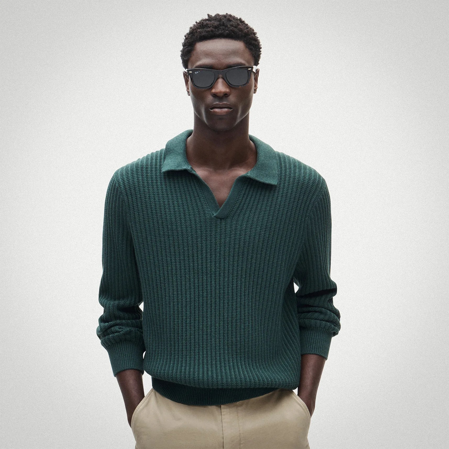 Dark green waffle knit sweater with a collar worn with beige pants.