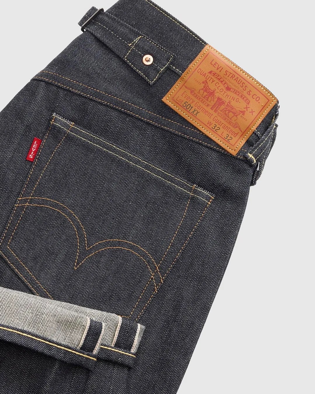 Dark indigo Levi's 501XX jeans with visible back pocket stitching, red Levi's tab, and leather brand patch.