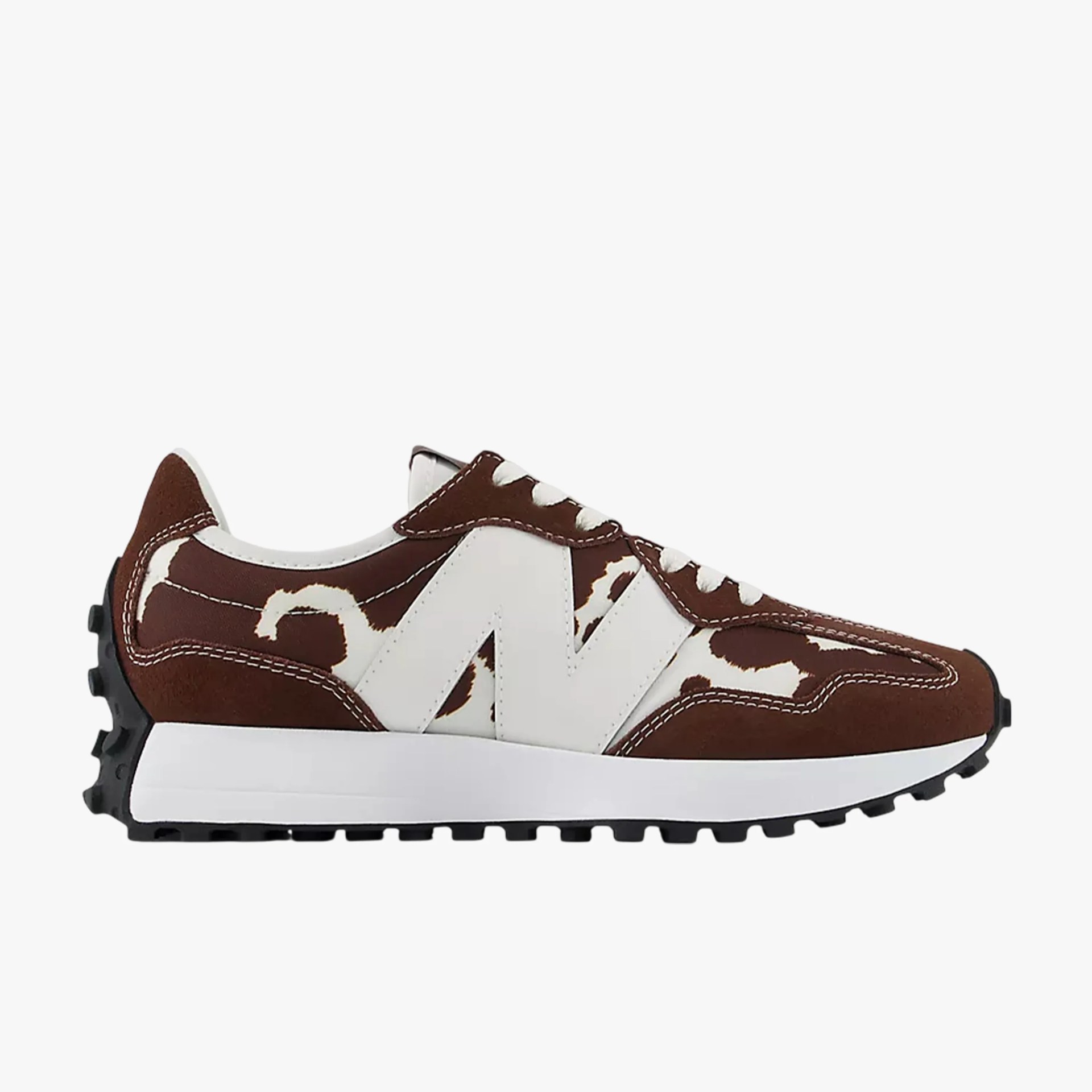 Brown and white New Balance sneaker with cow print pattern and black rubber sole.