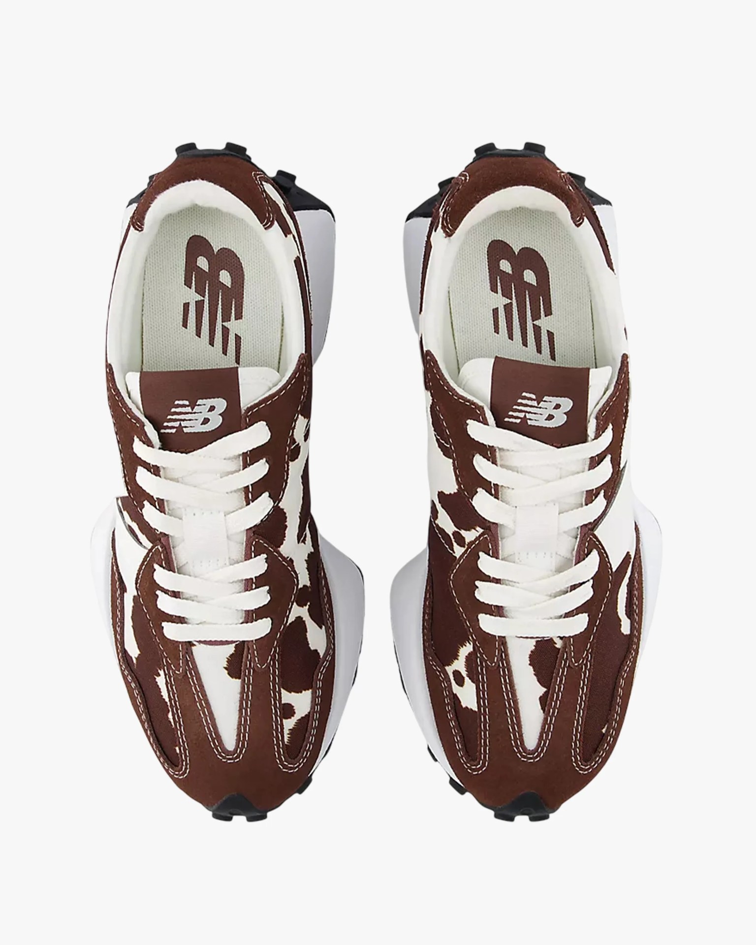 Pair of brown and white New Balance sneakers with cow print pattern and white laces viewed from above.