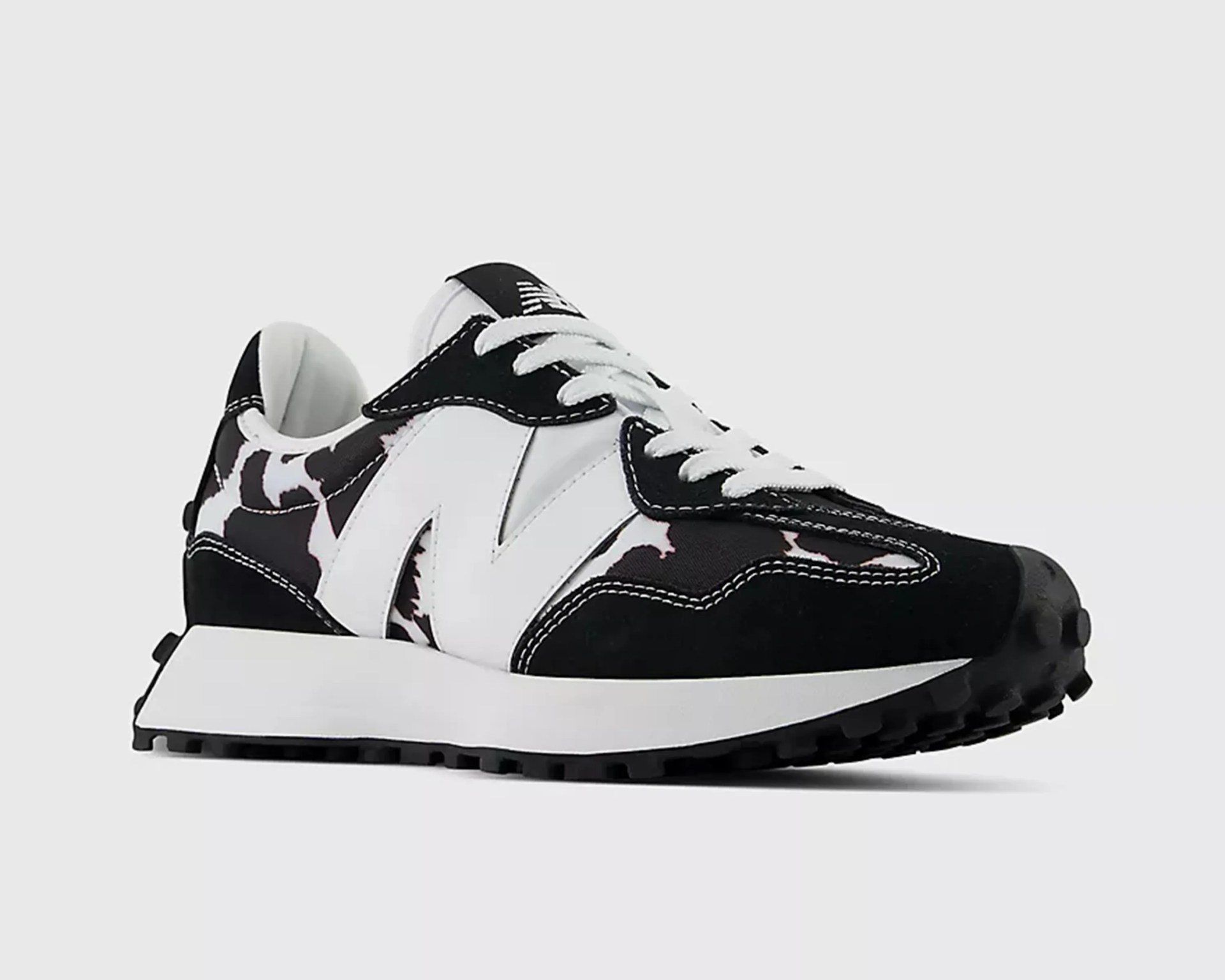 Black and white sneaker with large white "N" logo and black and white camouflage pattern on upper.
