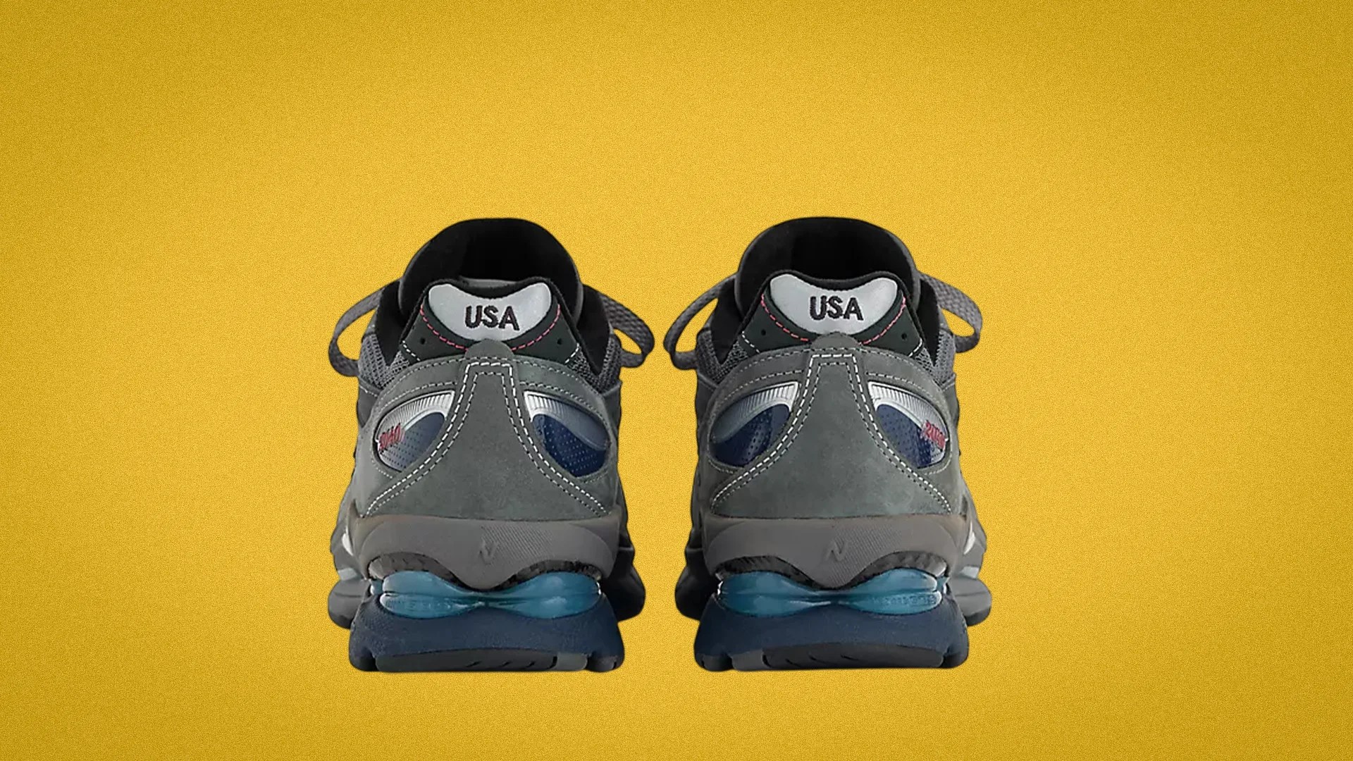 Pair of gray and blue athletic shoes with "USA" text on the heel against a yellow background.