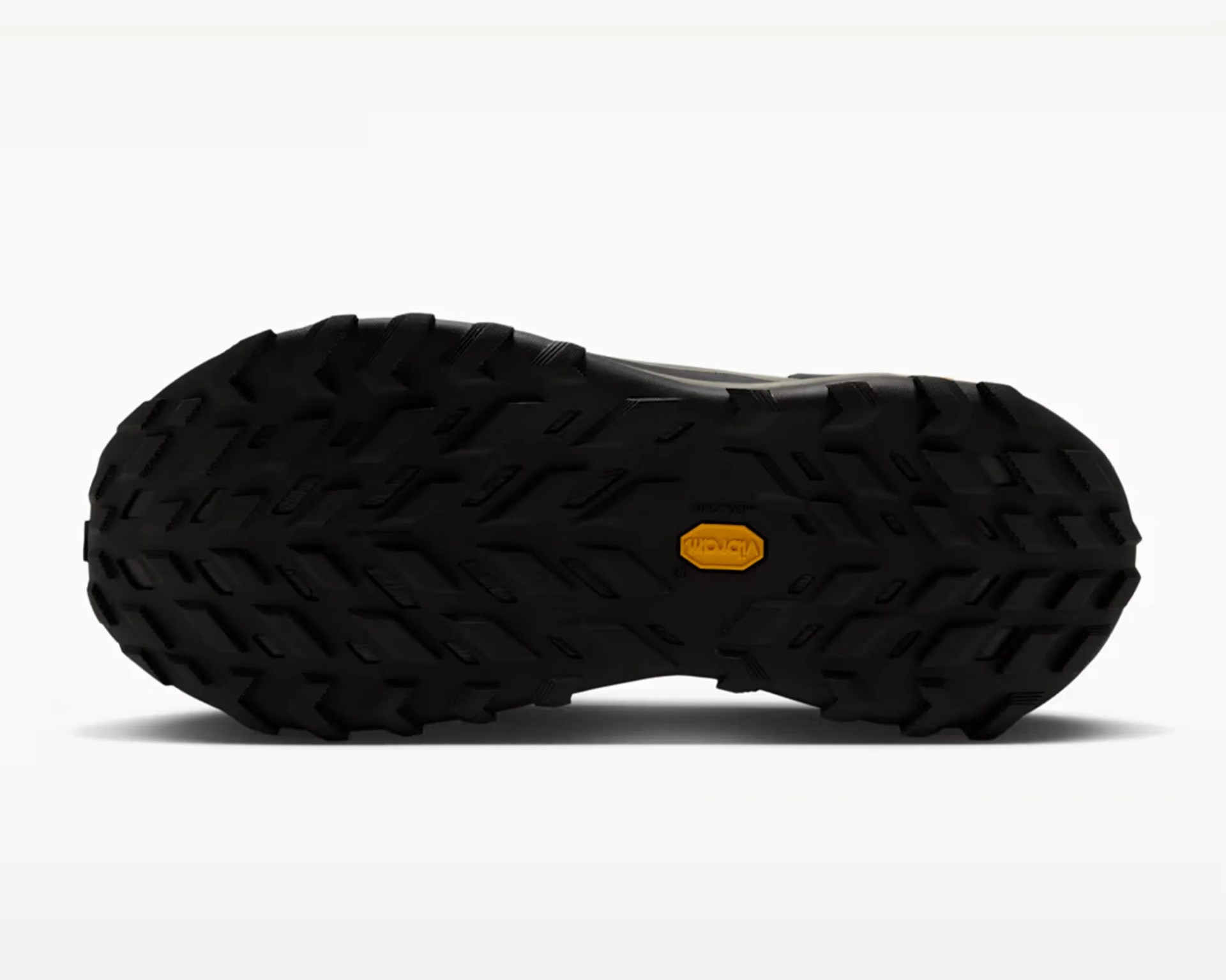 Black rugged shoe sole with deep treads and a yellow Vibram logo in the center.