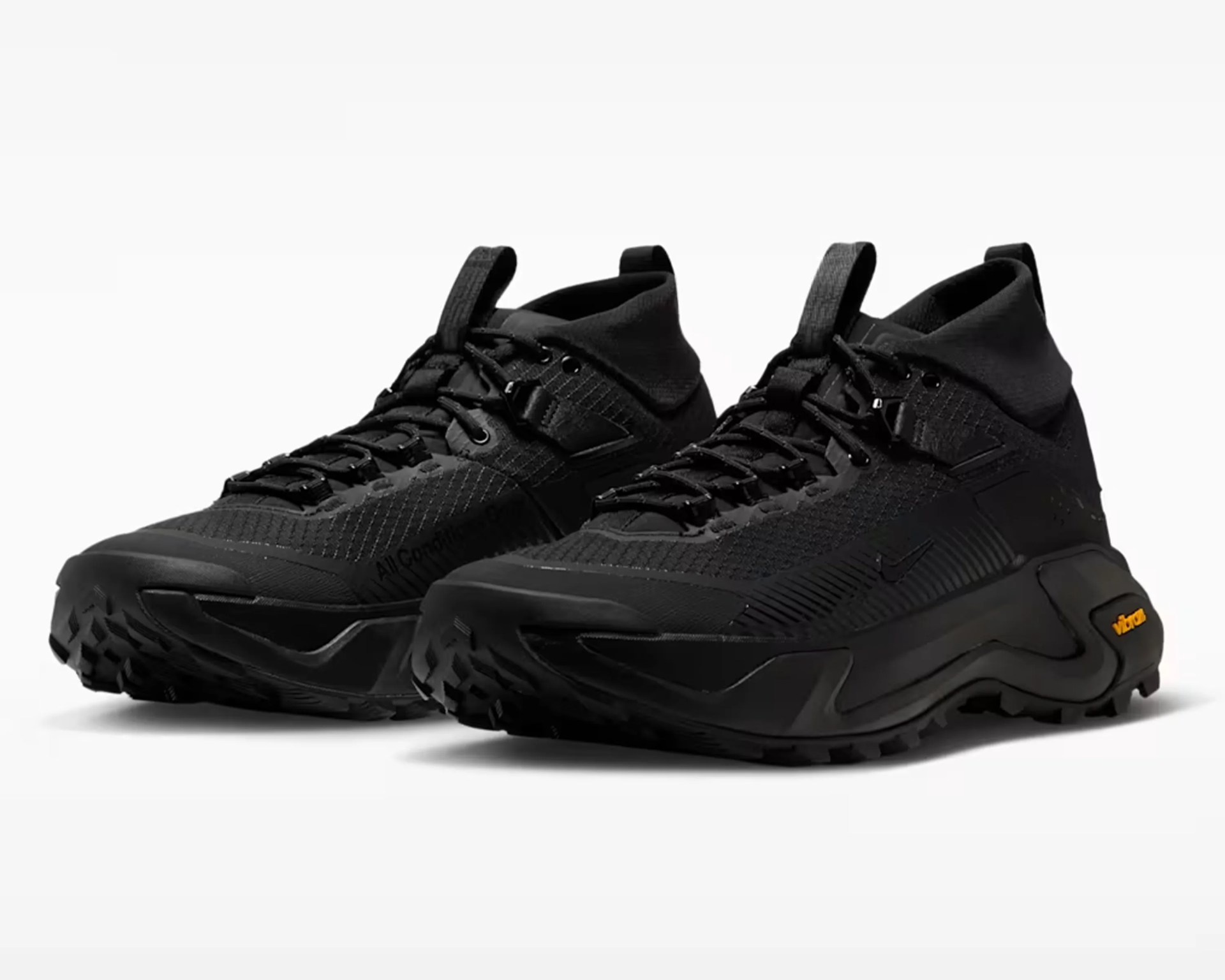 Pair of black high-top athletic shoes with textured uppers and Vibram soles on a white background.