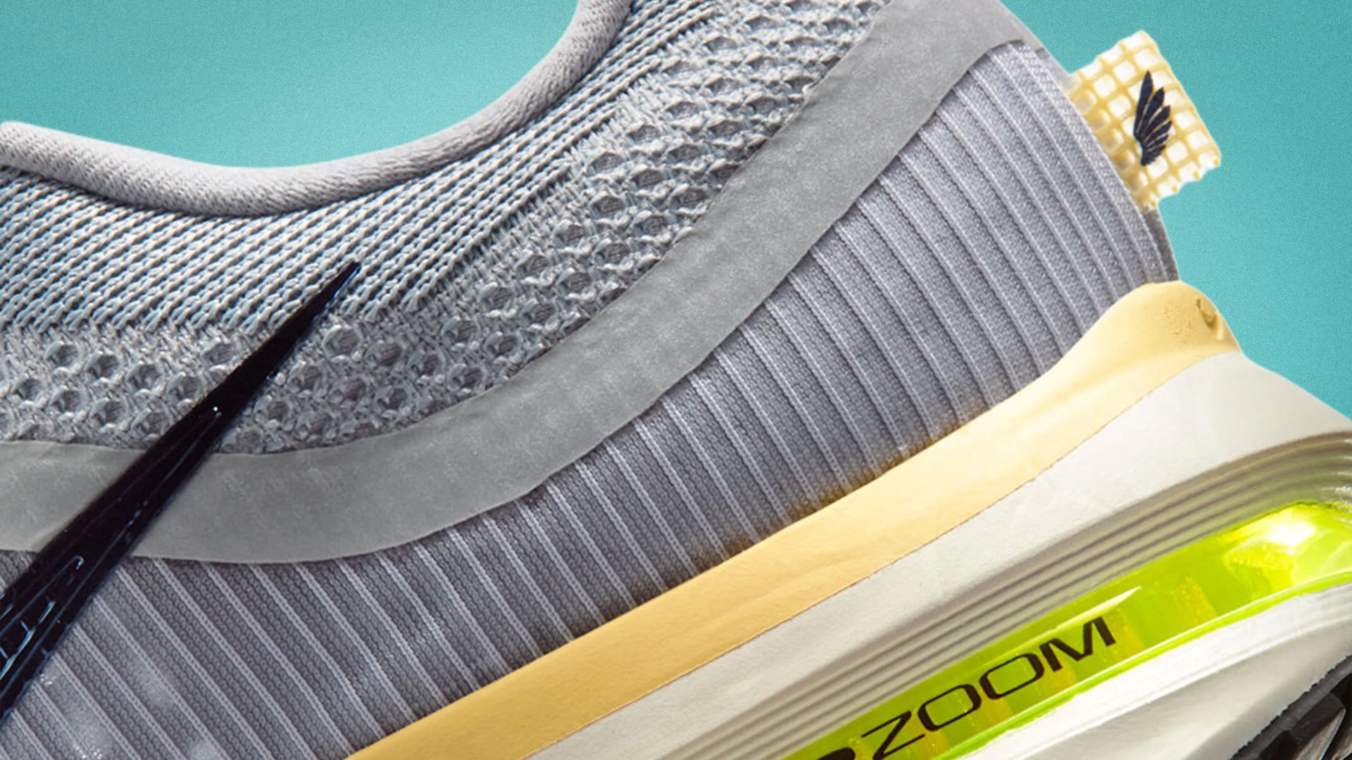Close-up of a gray Nike sneaker with knit upper, yellow midsole, and visible neon green Zoom Air cushioning.