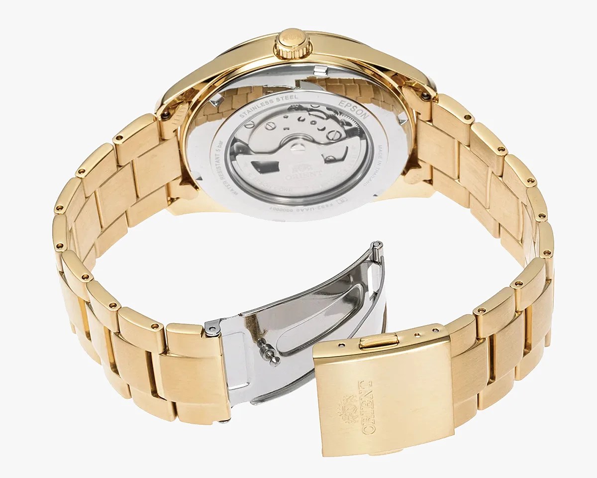 Gold-tone stainless steel watch band with a deployment clasp and visible automatic movement through the transparent case back.