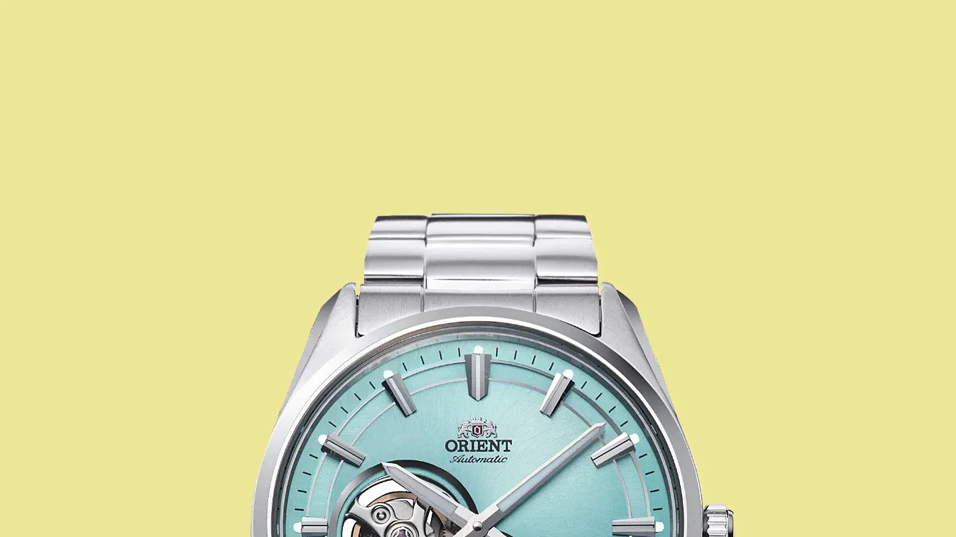 Silver stainless steel wristwatch with a light blue dial and visible mechanical movement.