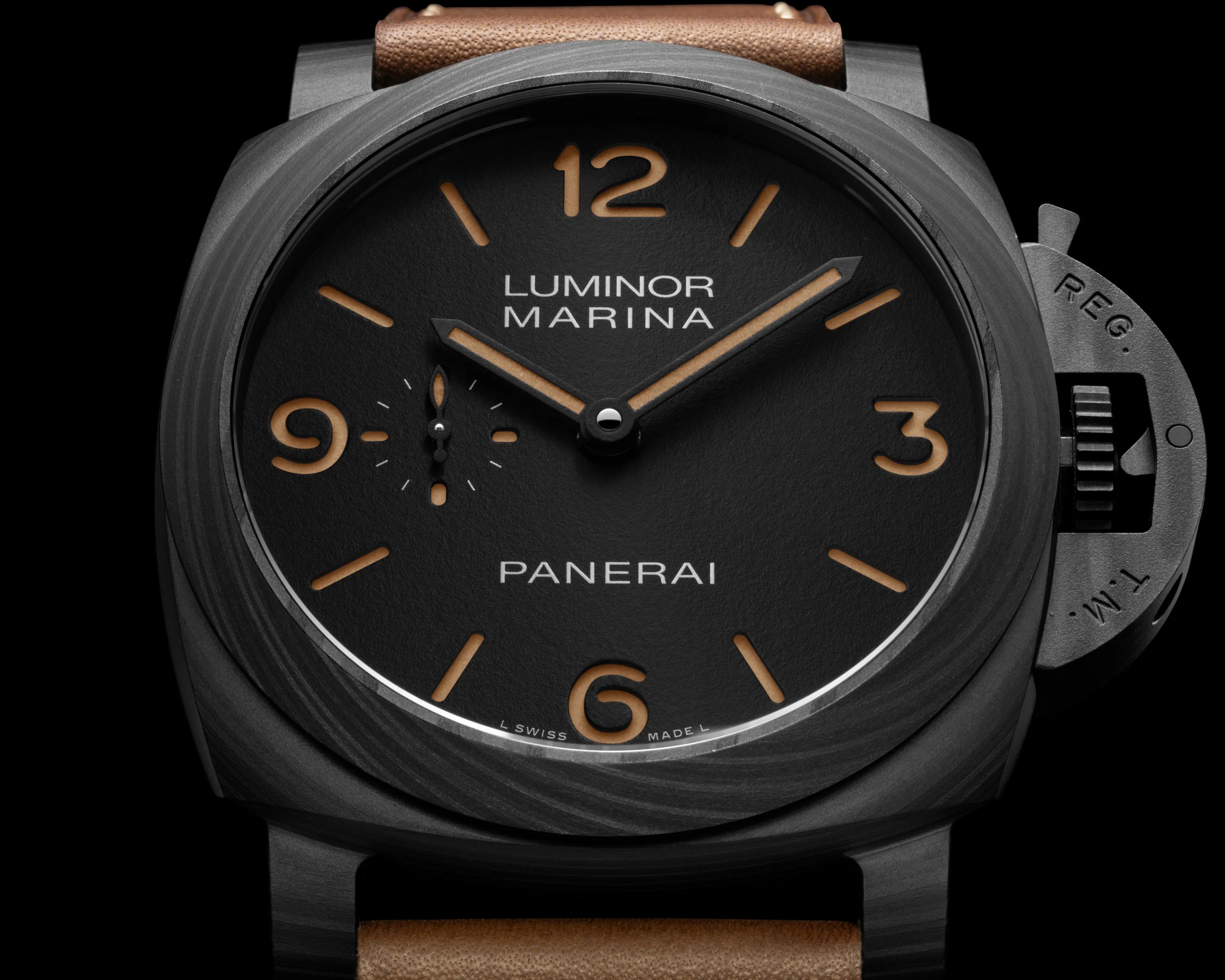 Close-up of a black Panerai Luminor Marina watch face with tan numerals and markers, black case, and brown leather strap.