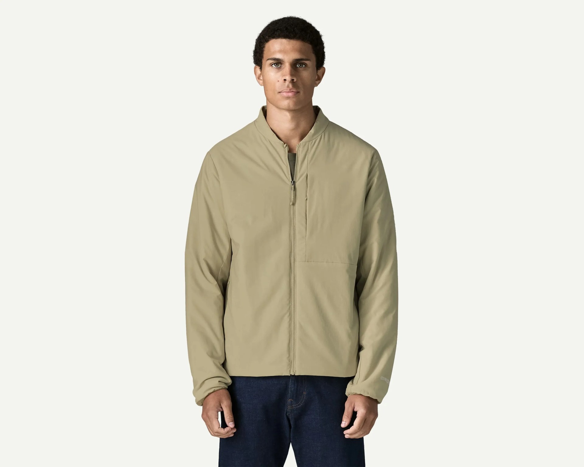 Light brown zip-up jacket with a stand collar worn by a person against a plain background.