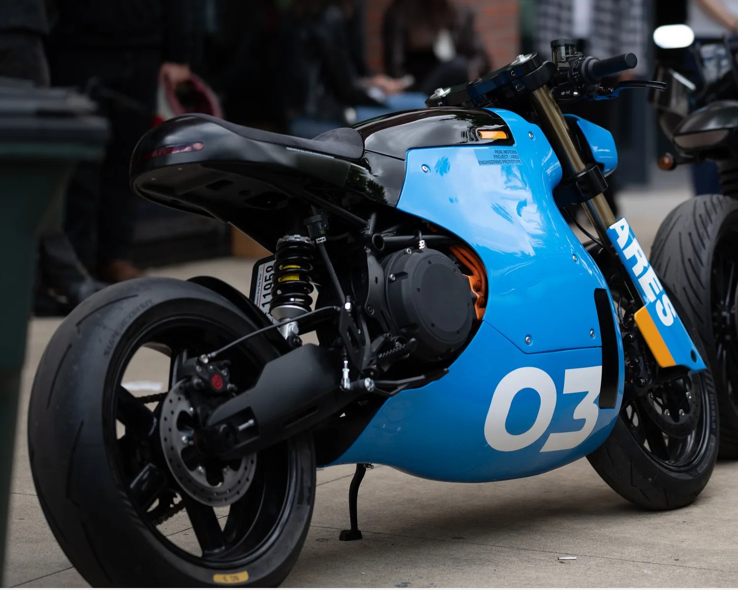 Blue and black electric motorcycle with number 03 and "ARES" text on the front fairing.