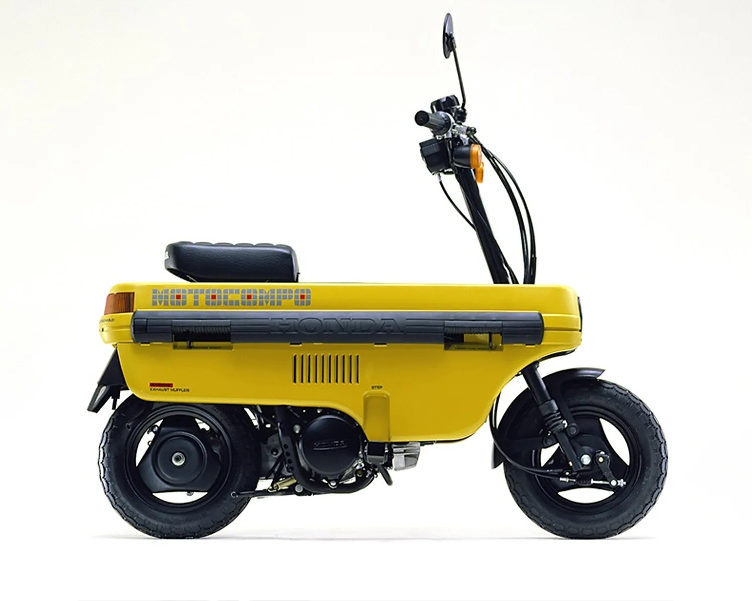 Yellow Honda Motocompo compact folding scooter with black seat and tires on a white background.