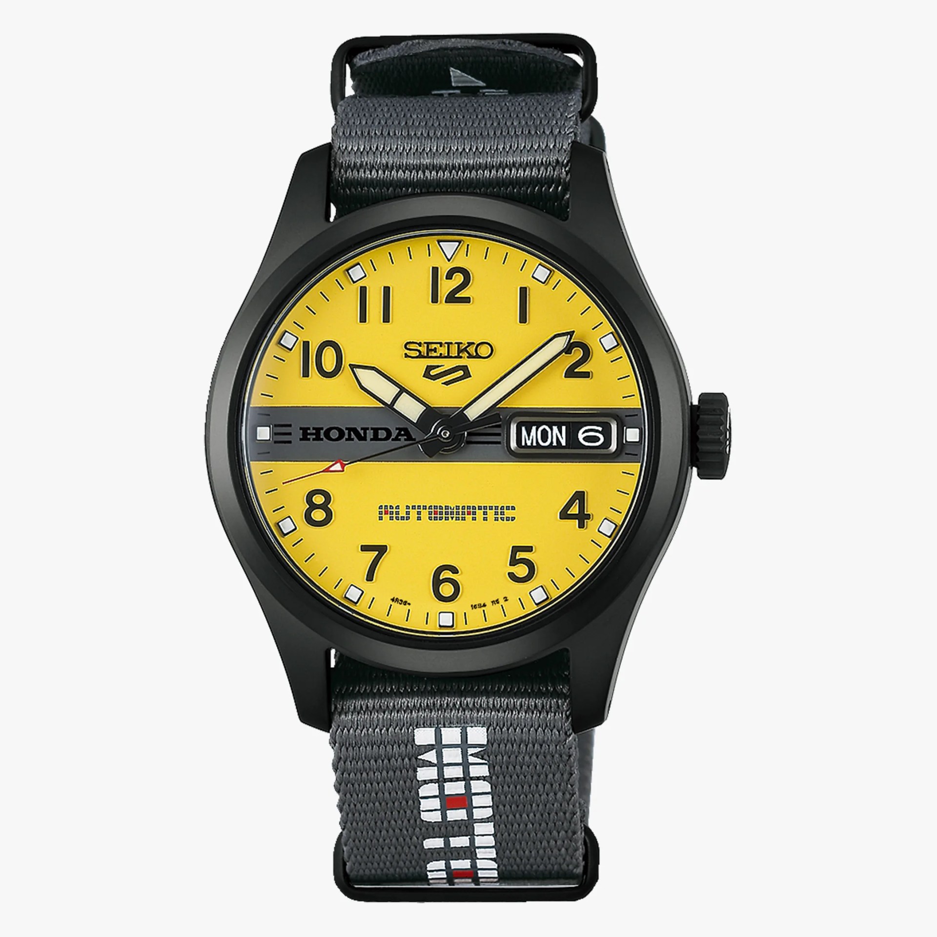 Black Seiko wristwatch with yellow dial, black numerals, day-date display, and gray fabric strap with white and red pattern.
