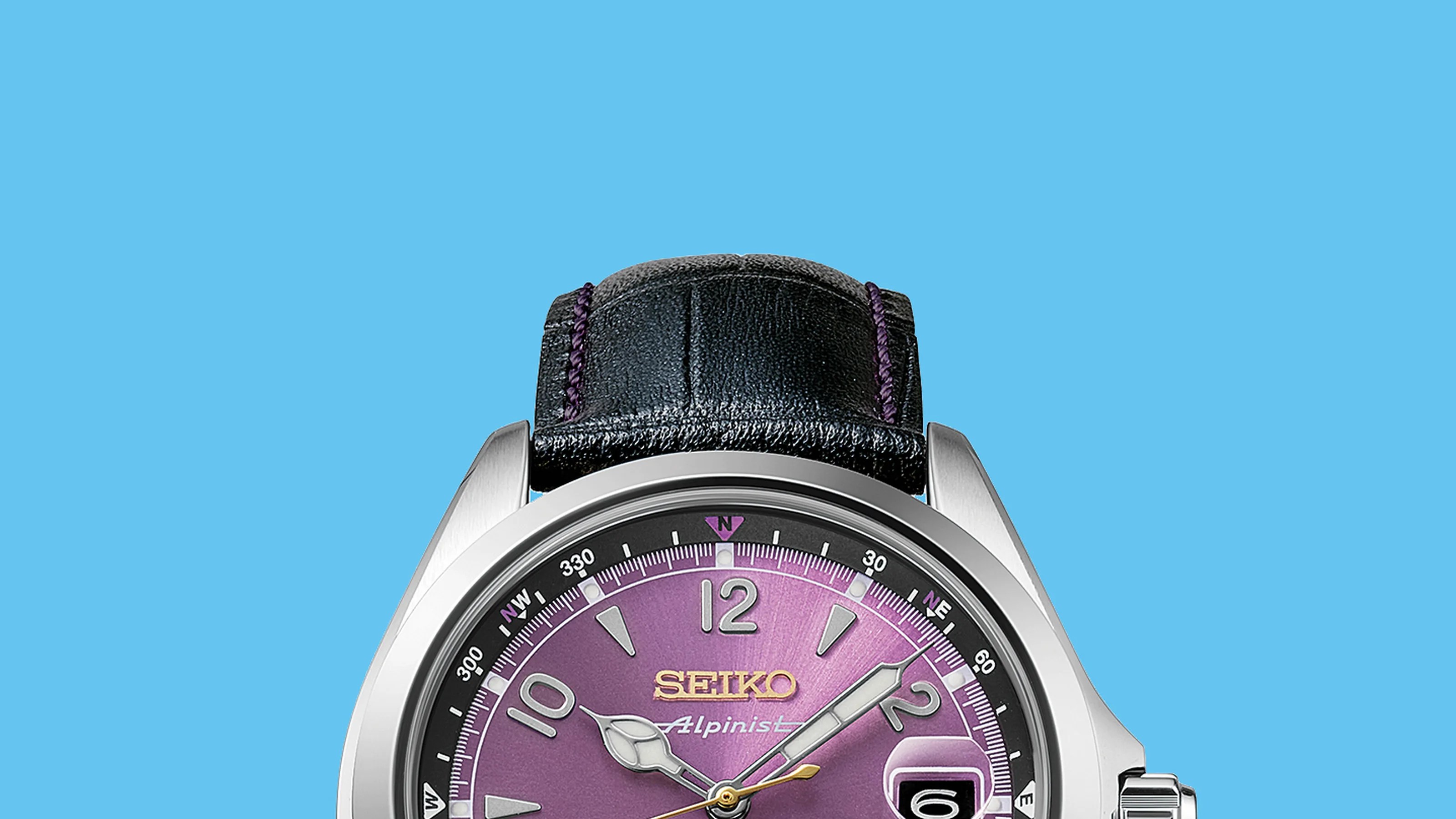 Close-up of a Seiko Alpinist watch with a purple dial, silver case, black leather strap with purple stitching, and date window.