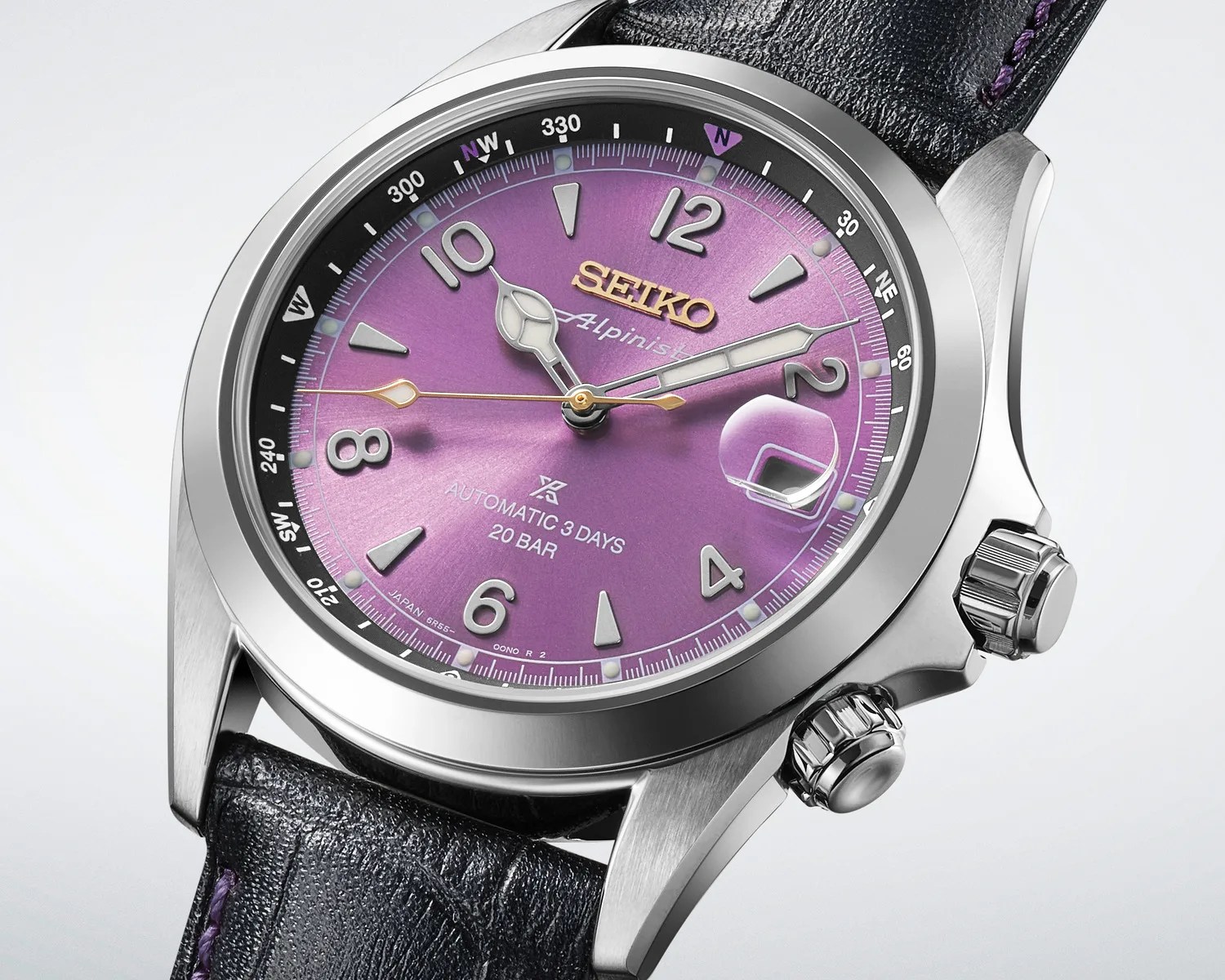 Close-up of a Seiko Alpinist watch with a purple dial, silver case, black leather strap, and gold second hand.