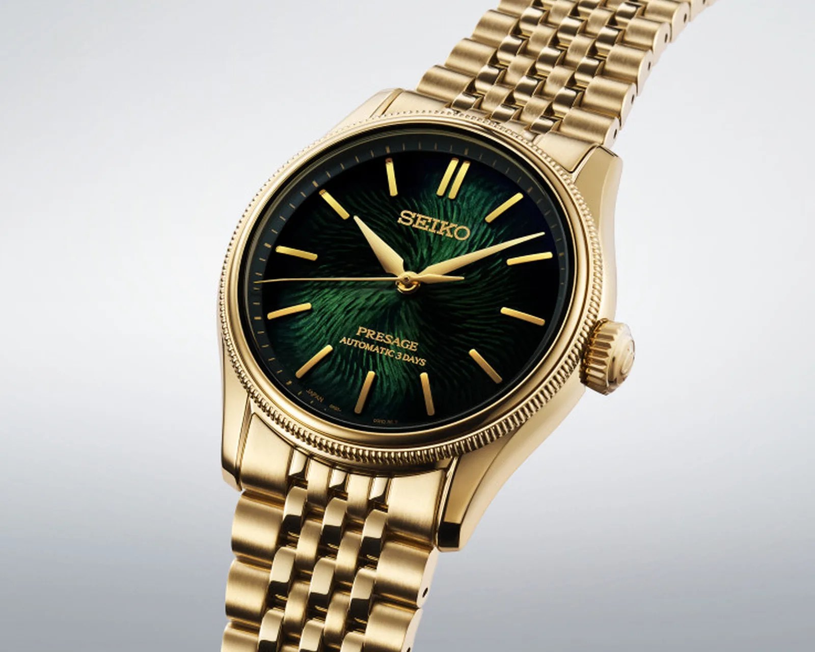 Gold Seiko Presage wristwatch with a textured green dial and gold bracelet band.