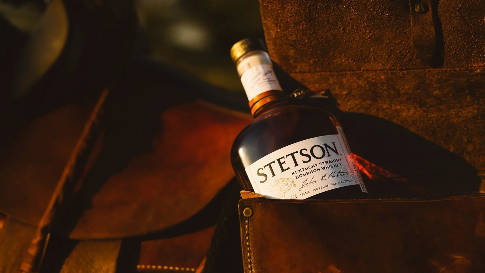 Bottle of Stetson Kentucky Straight Bourbon Whiskey resting in a brown leather bag.
