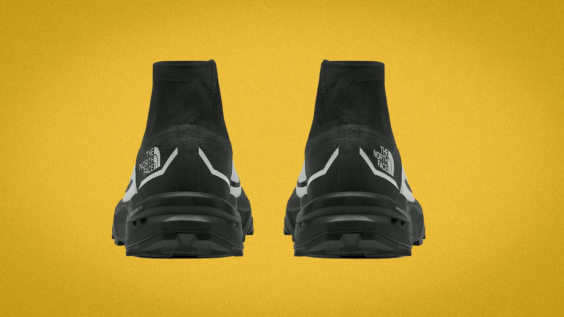 Pair of black high-top The North Face trail running shoes shown from the back on a yellow background.