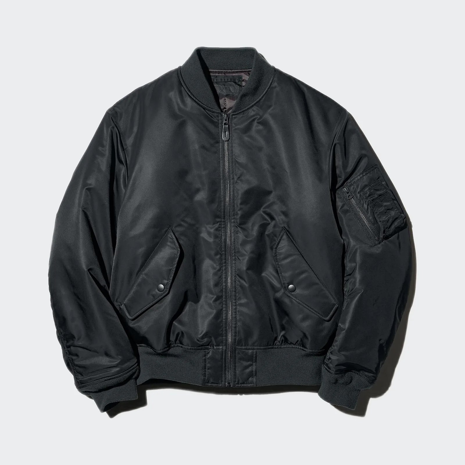Black bomber jacket with front zipper, snap-button flap pockets, ribbed collar, cuffs, and hem, and zippered sleeve pocket.