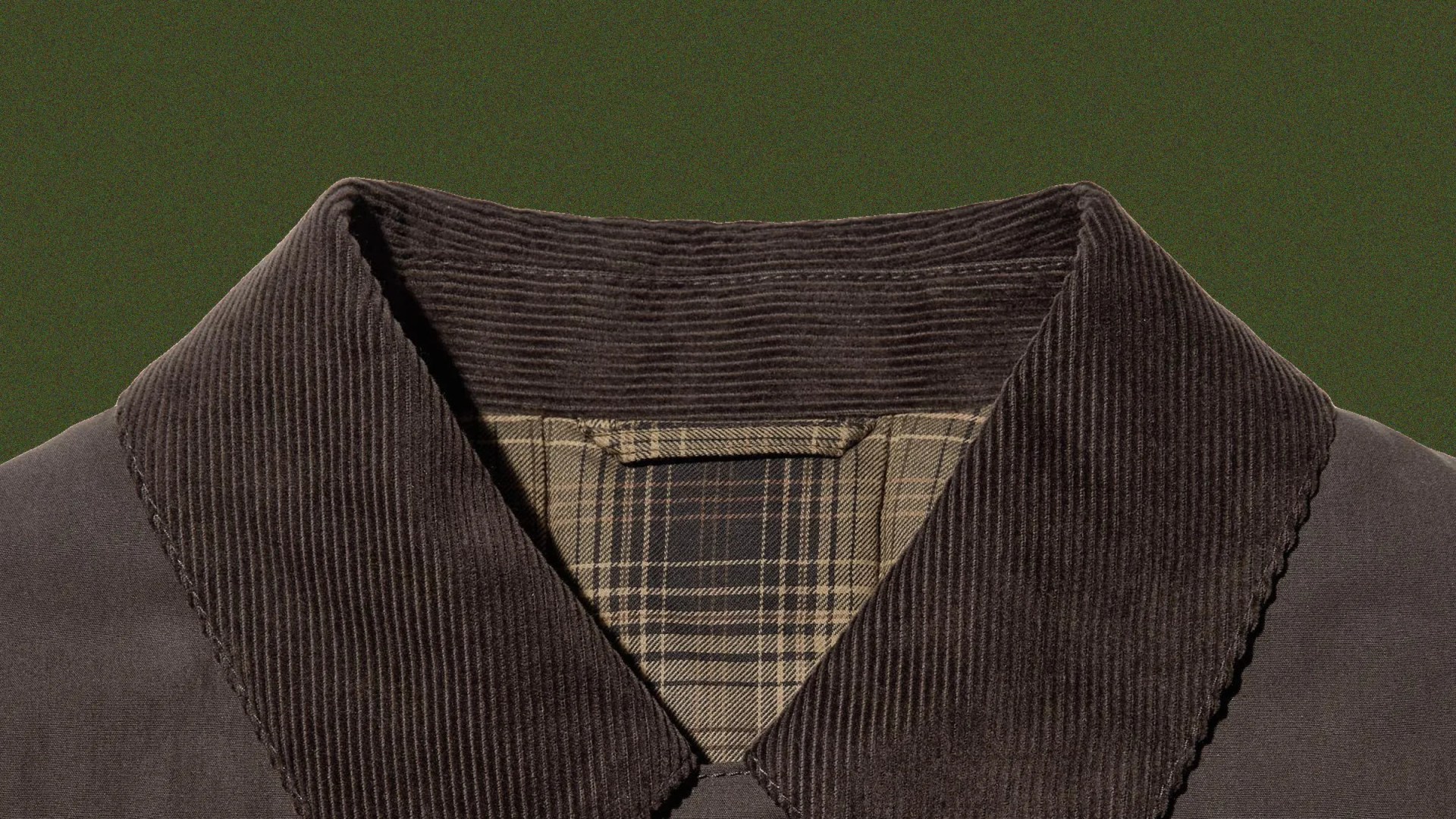 Dark brown corduroy jacket collar with beige and brown plaid lining visible inside.