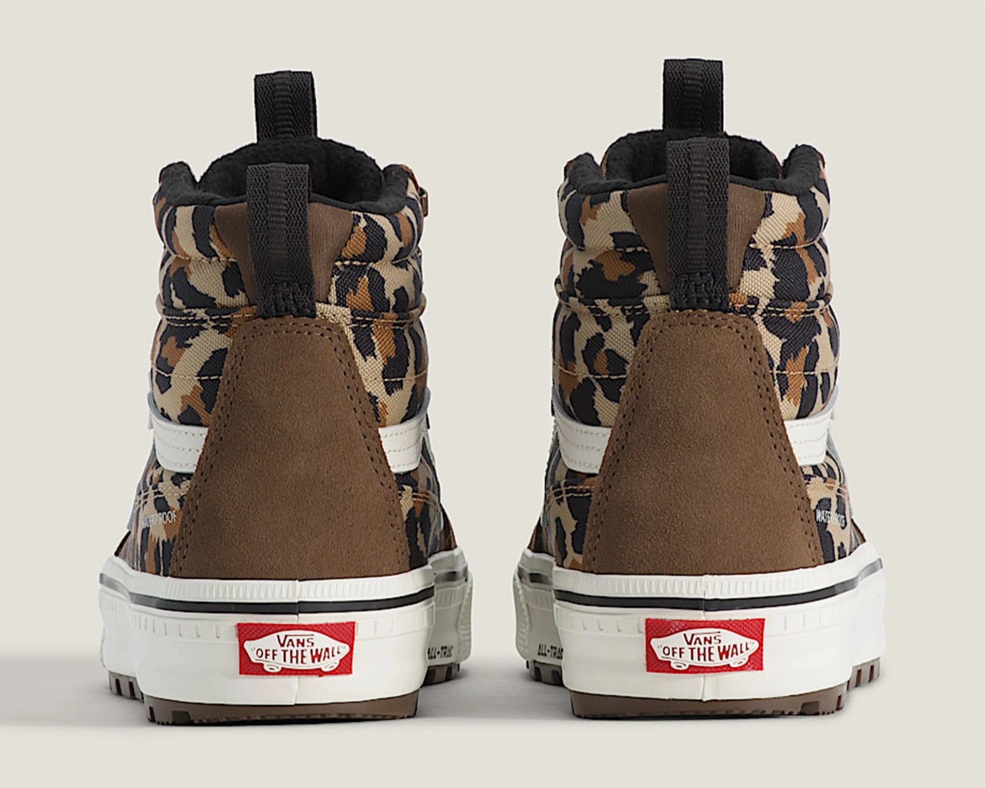 Pair of Vans high-top sneakers with brown suede heel panels and leopard print fabric uppers, viewed from the back.