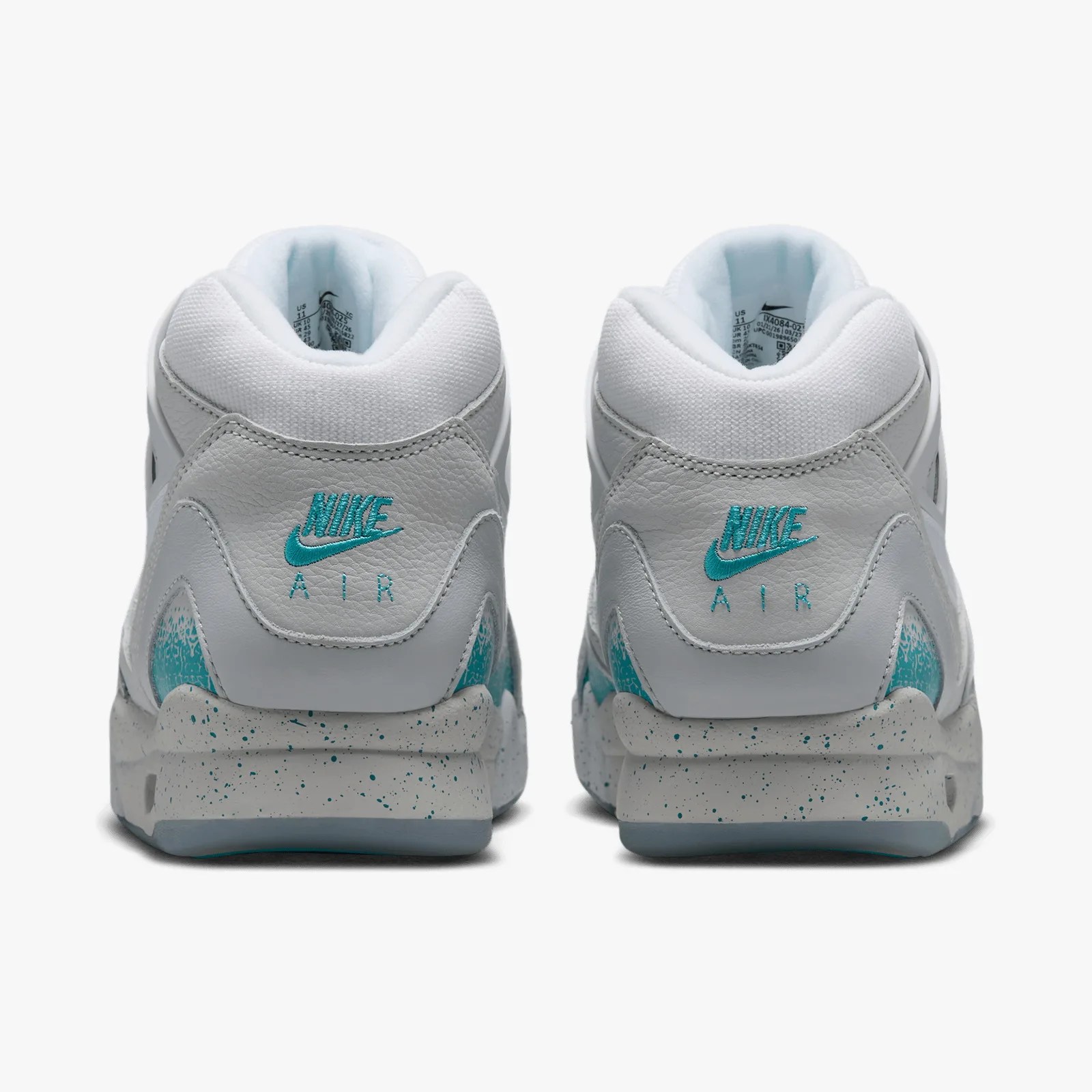 Pair of white Nike Air sneakers with teal logo and speckled gray midsoles, viewed from the back.